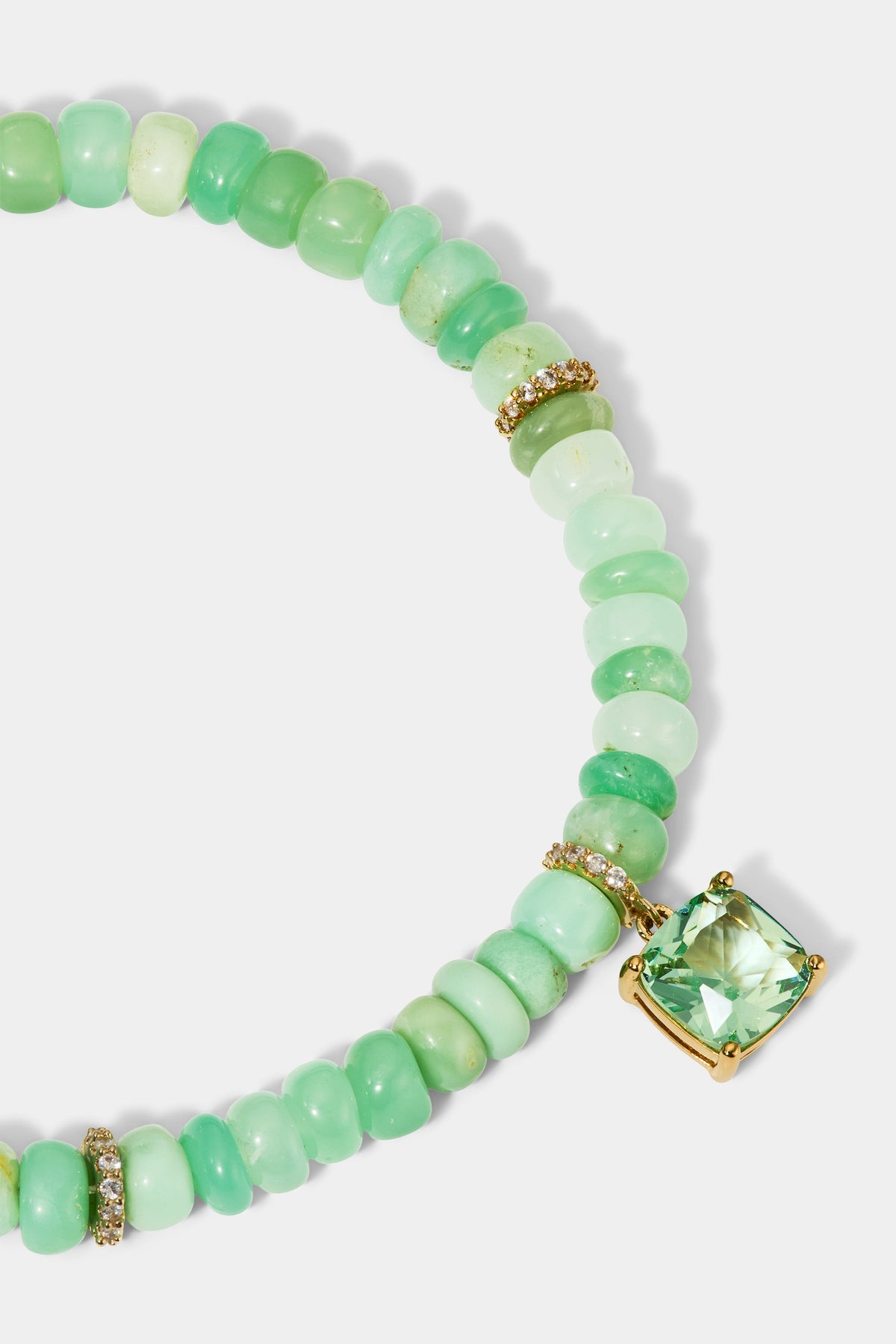 CLOSE UP OF THE CUSHION CHARM ON THE BEADS OF PARADISE GREEN CUSHION BOLO BRACELET