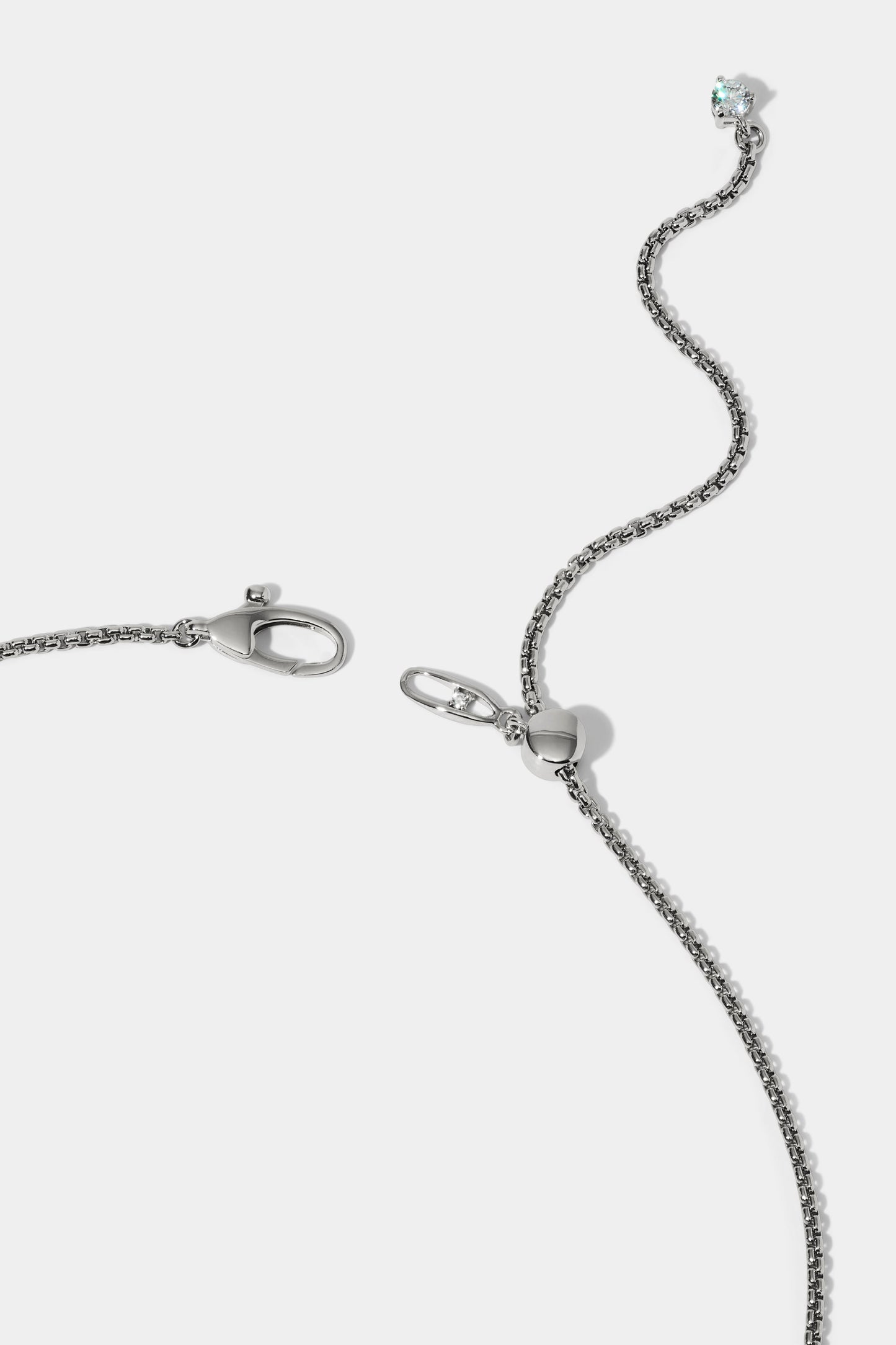 CLOSE UP OF THE CLASP ON THE LUCIA FRONTAL V NECKLACE, SHOWING A RHODIUM CHAIN WITH AN ADJUSTABLE EXTENSION FINISHED WITH A CZ STONE AT THE END