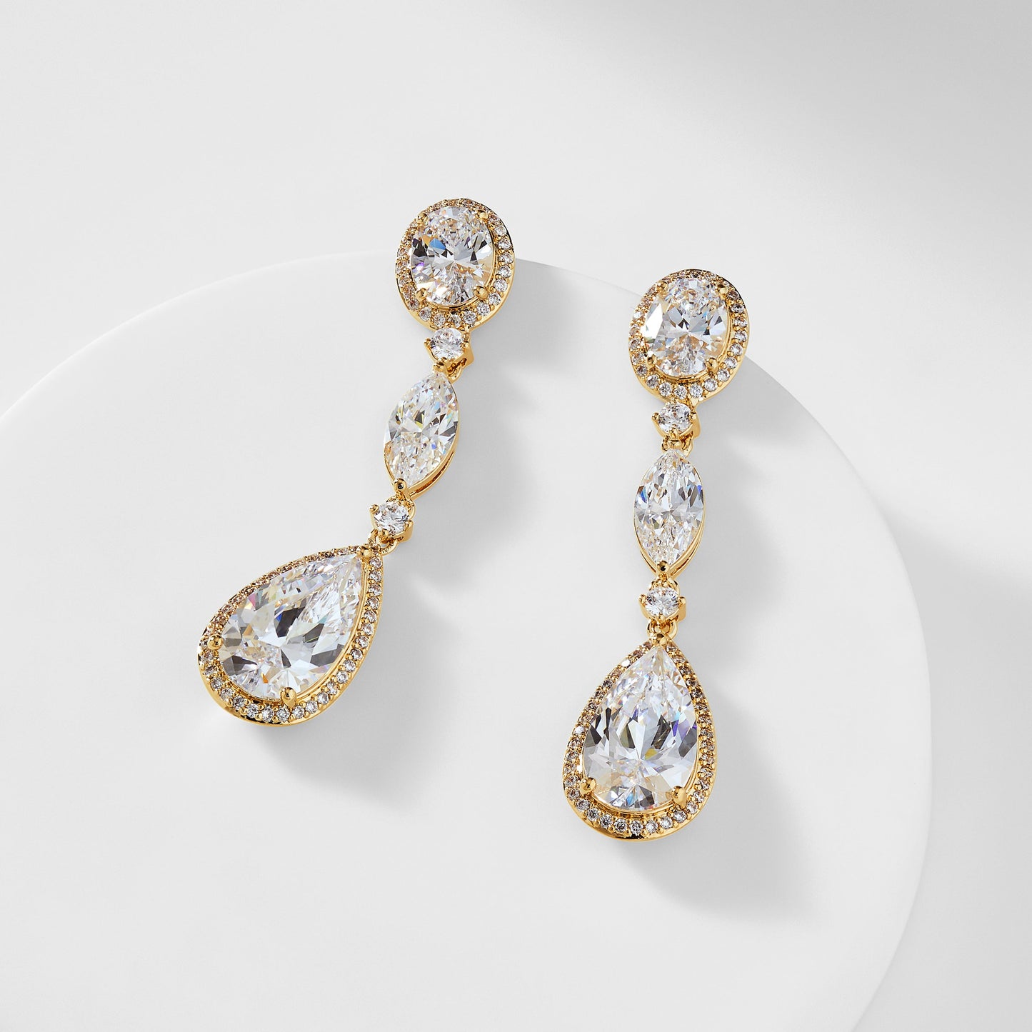 CZ PEAR AND OVAL DROP EARRINGS IN GOLD PLATING.