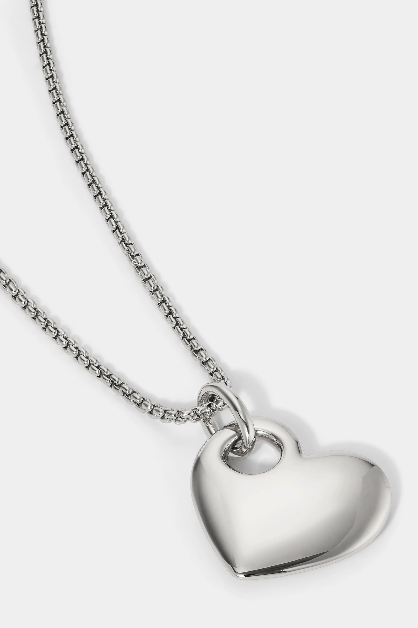 CLOSE UP DETAILED SHOT OF THE SUNLIGHT HEART PENDANT NECKLACE IN RHODIUM PLATING.