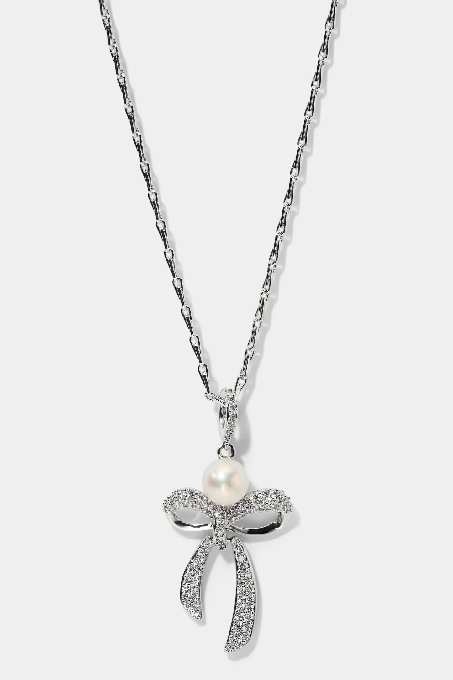EROS BOW AND PEARL PENDANT NECKLACE IN RHODUM PLATING