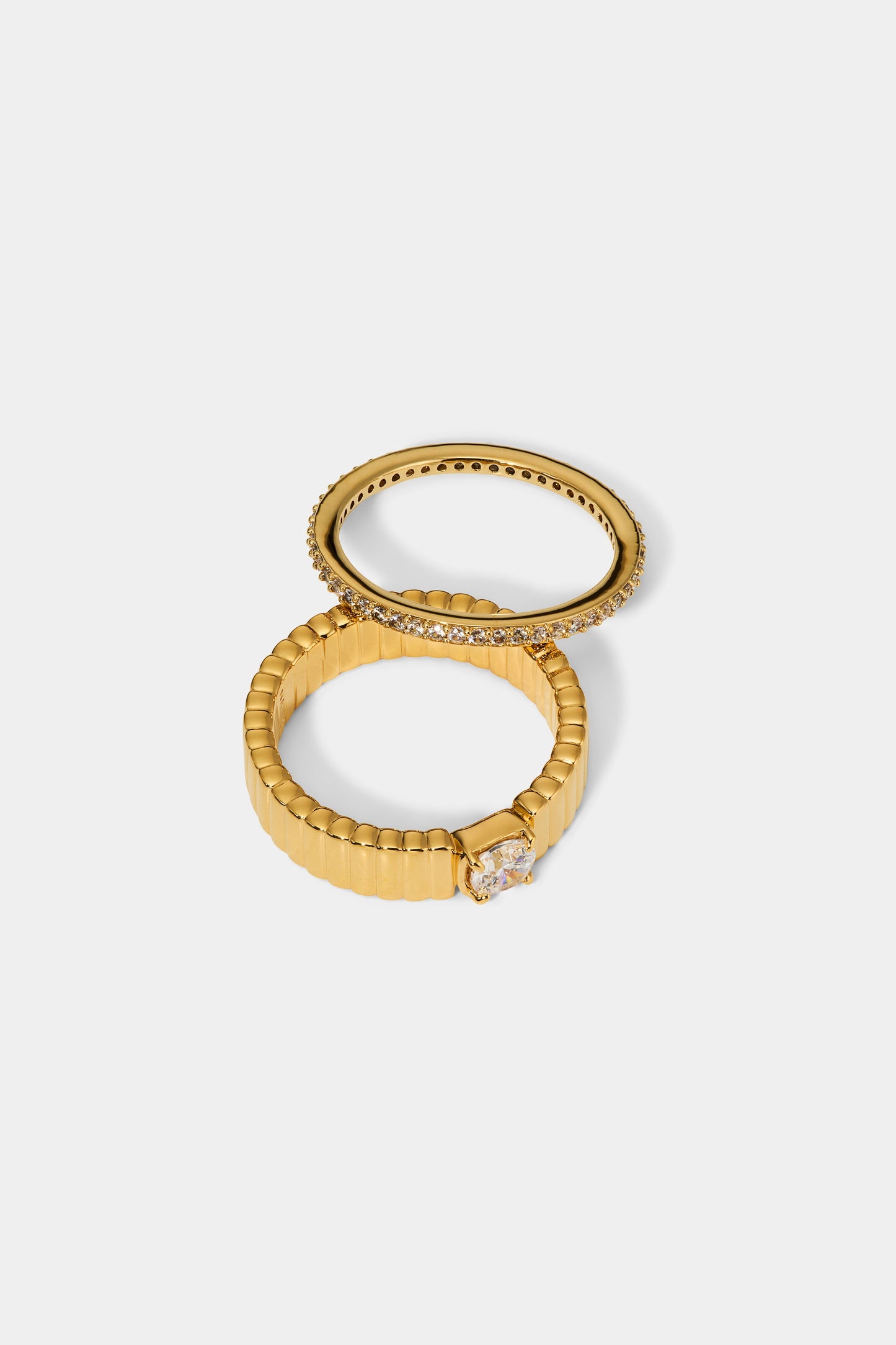 DELANCEY SOLITAIRE RING SET IN GOLD PLATING, SLIGHTLY SEPARATED TO SHOW TWO SEPARATE RINGS