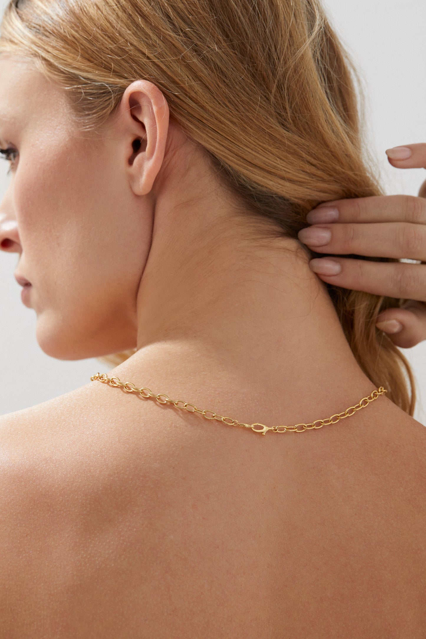 BACK VIEW OF BLUE LAGOON HALF COLLAR NECKLACE ON MODEL SHOWING THE NECKLACE CLASP AND DETAIL OF CHAIN. 