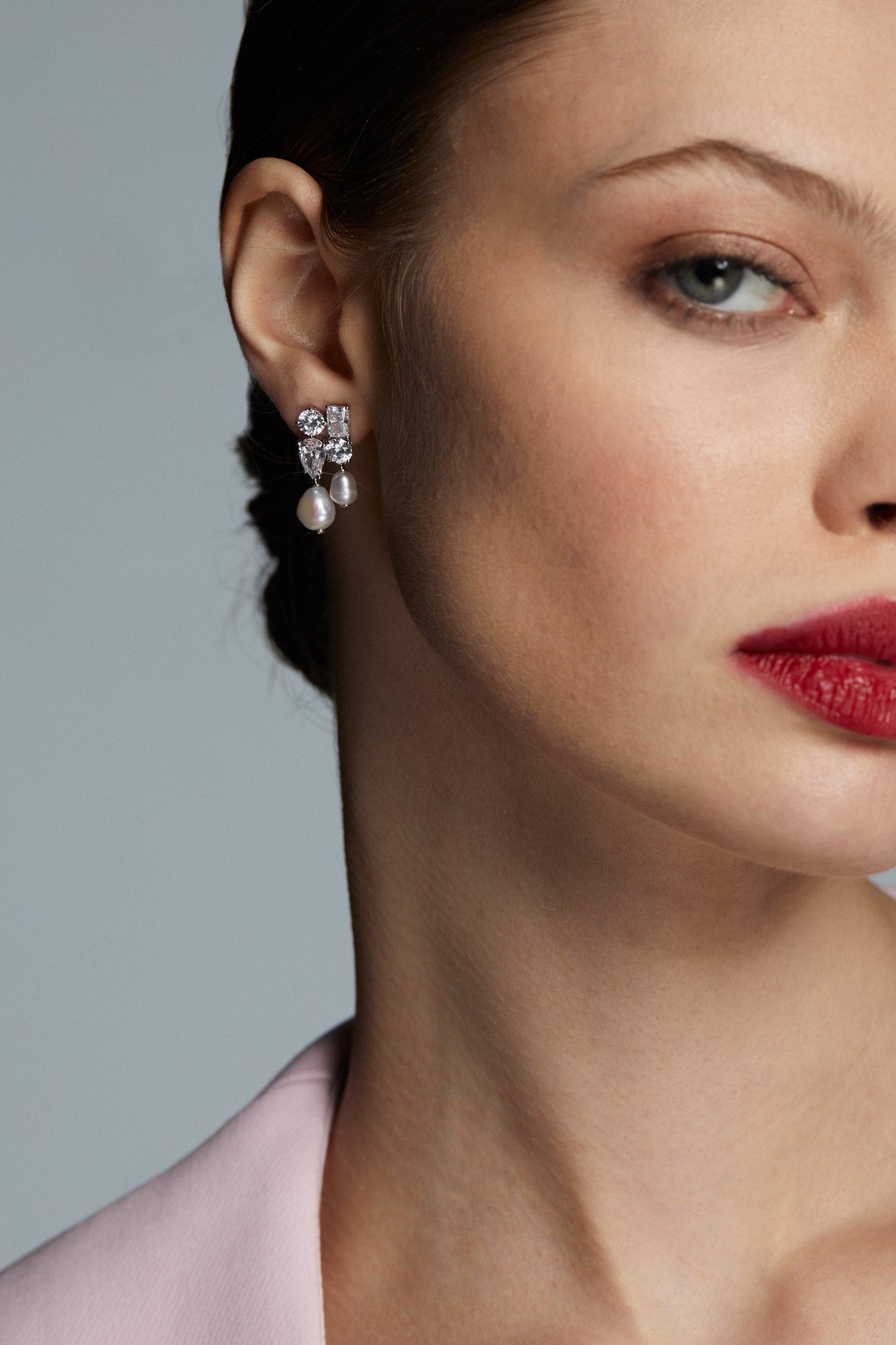 LONDON CLUSTER CZ PEARL DROP EARRINGS ON MODEL. IT IS A CLOSE UP SHOT WITH A DETAIL VIEW ON THE EARRING ON FOR SCALE. 