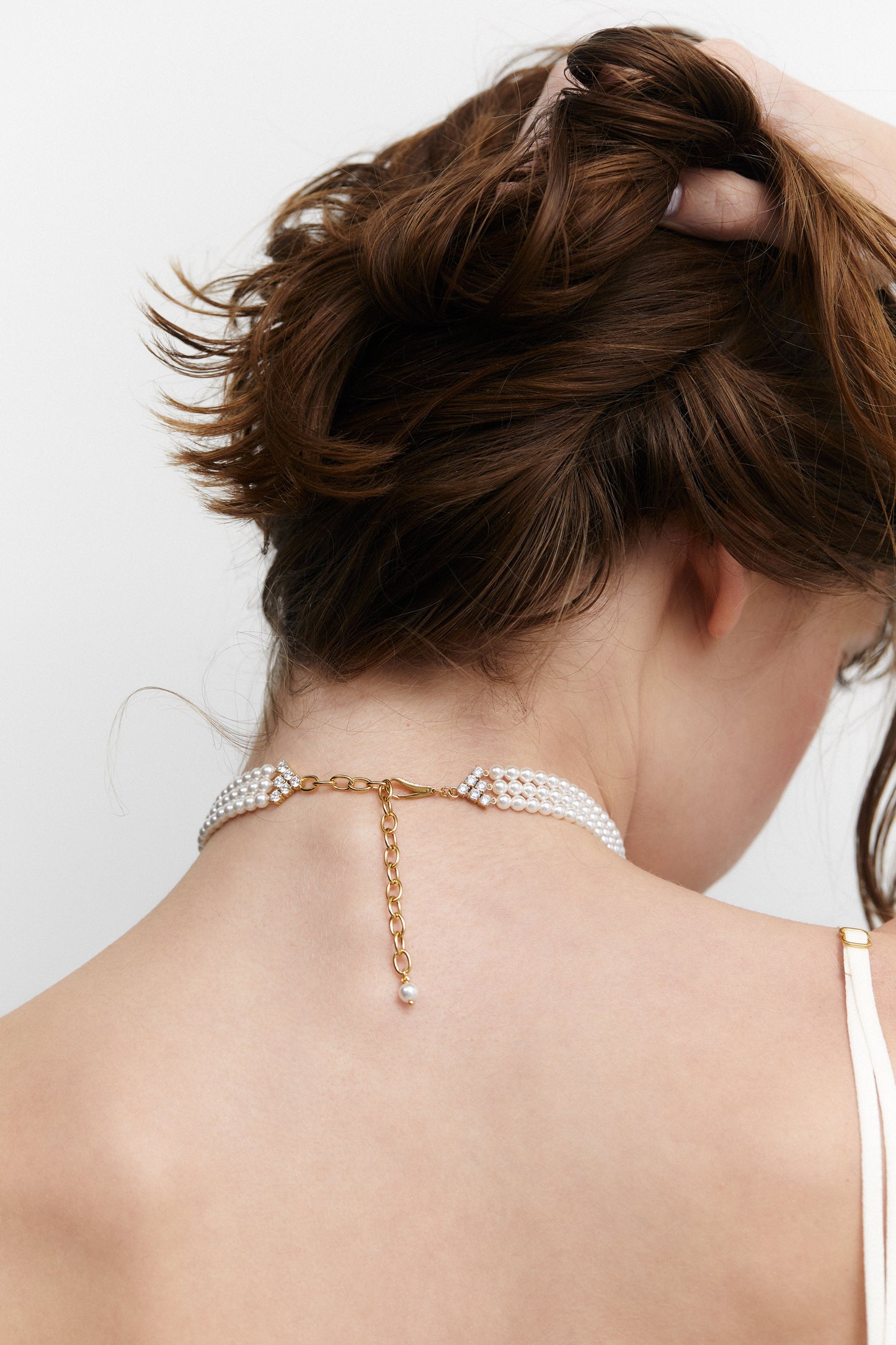 BACK VIEW OF MODEL WEARING MADRID 4MM  PEARL CHOKER NECKLACE TO SHOW THE CLOSURE DETAIL.