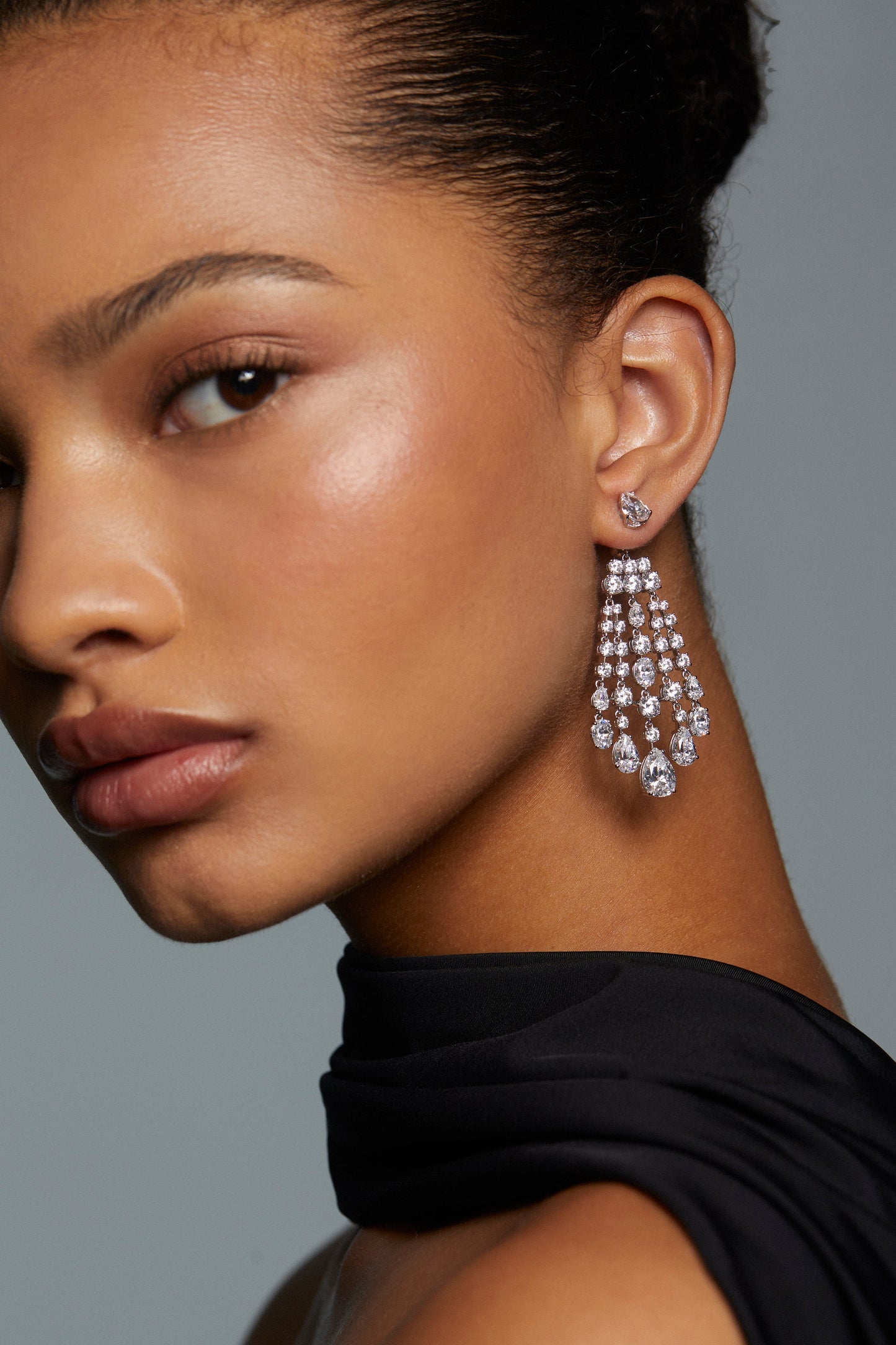 Model wearing front and back chandelier earrings with mixed-cut CZ stones.