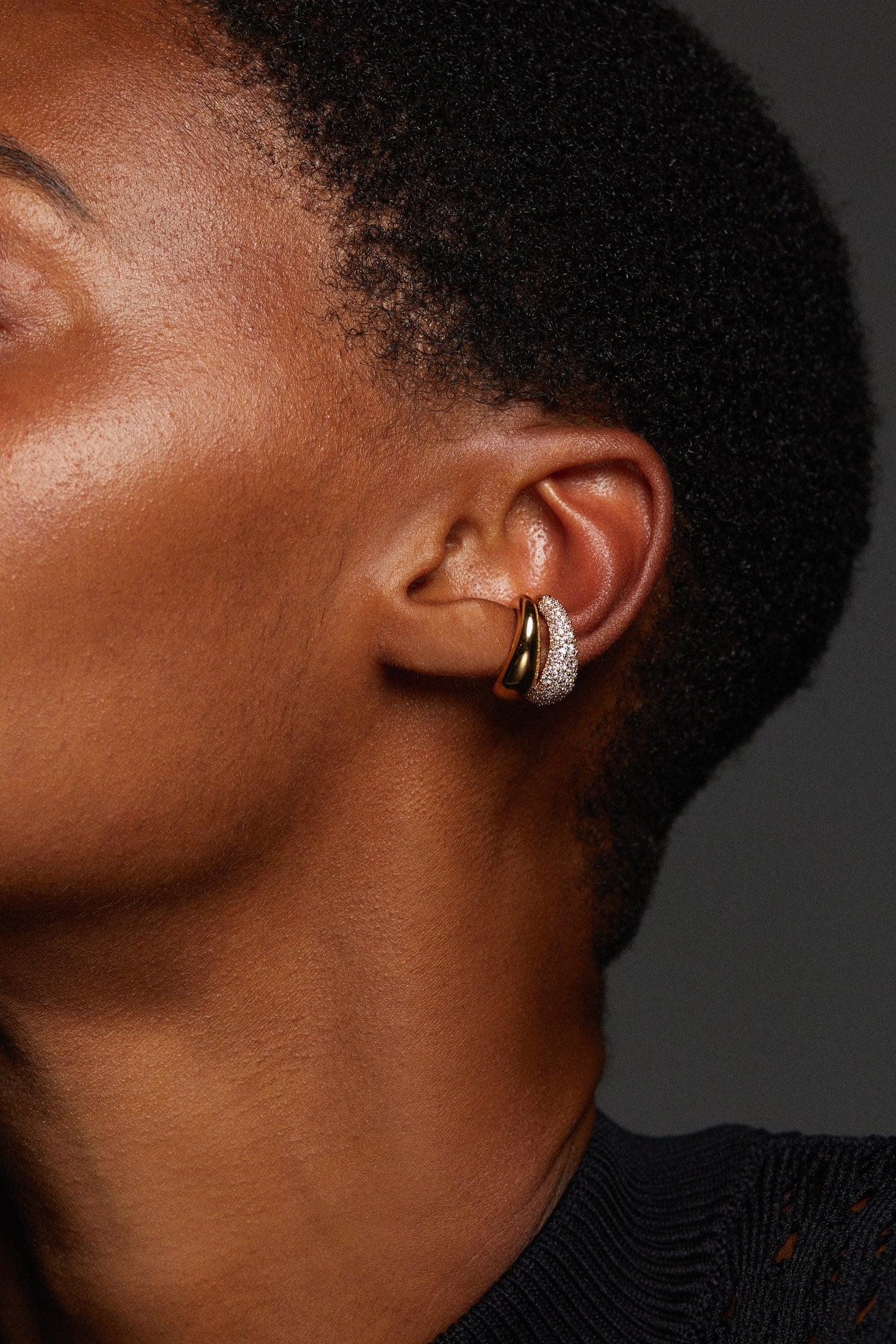 MODEL WEARING PISA EAR CUFF SET OF EARRINGS. SHE HAS A BUZZ CUT SHORT HAIR AND THE IMAGE IS A CLOSE UP OF HER EAR SHOWING THE CUFFS STACKED SIDE BY SIDE. 