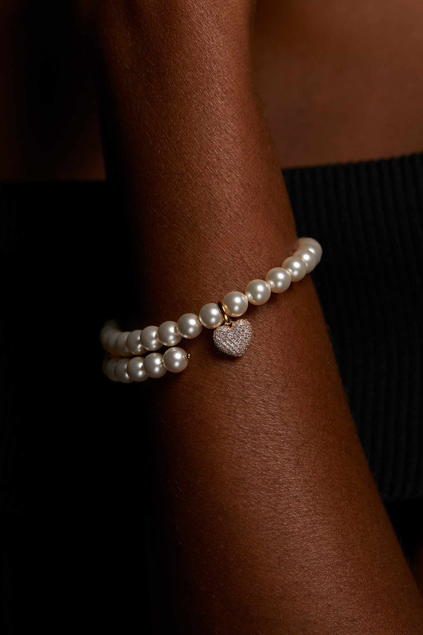 CLOSE UP IMAGE OF MODEL WEARING POPPY 6MM HEART PAVE CZ DOUBLE WRAP BRACELET. IT IS A TIGHT CROP OF HER WRIST. 