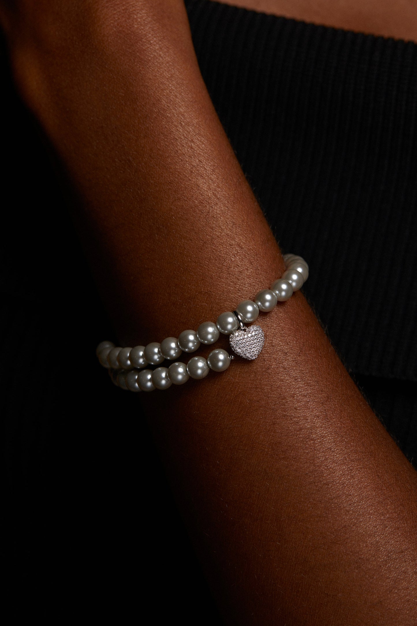 CLOSE UP IMAGE OF MODEL WEARING POPPY 6MM GRAY DOUBLE WRAP BRACELET. IT IS A TIGHT CROP OF HER WRIST. 