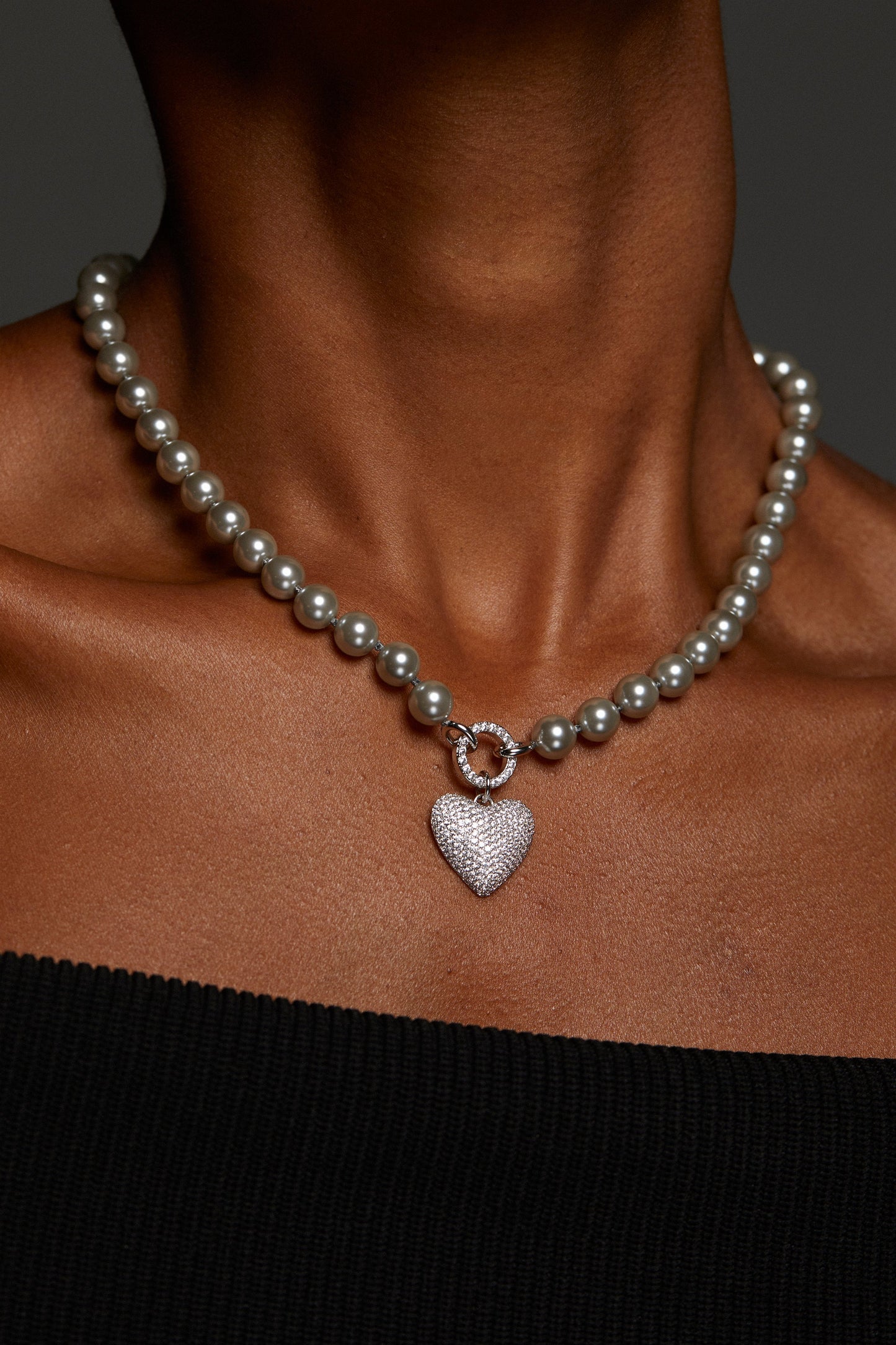 MODEL WEARING POPPY 8MM GRAY PEARL CZ HEART NECKLACE. IT IS A CLOSE UP IMAGE OF HER NECKLINE. 