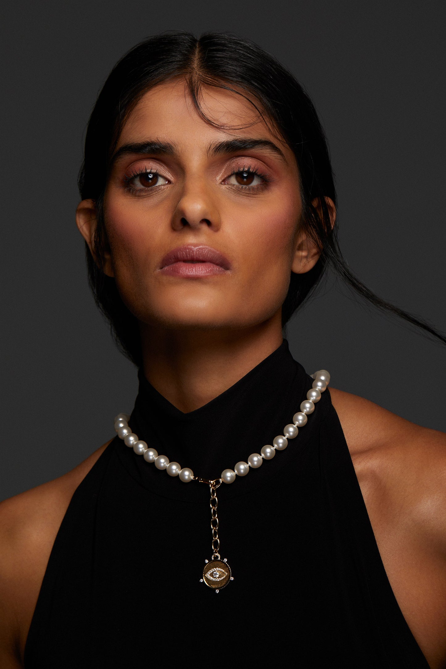 MODEL WEARING POPPY 10MM EVIL EYE NECKLACE. SHE HAS ON A BLACK SLEEVELESS TURTLENECK TOP. 