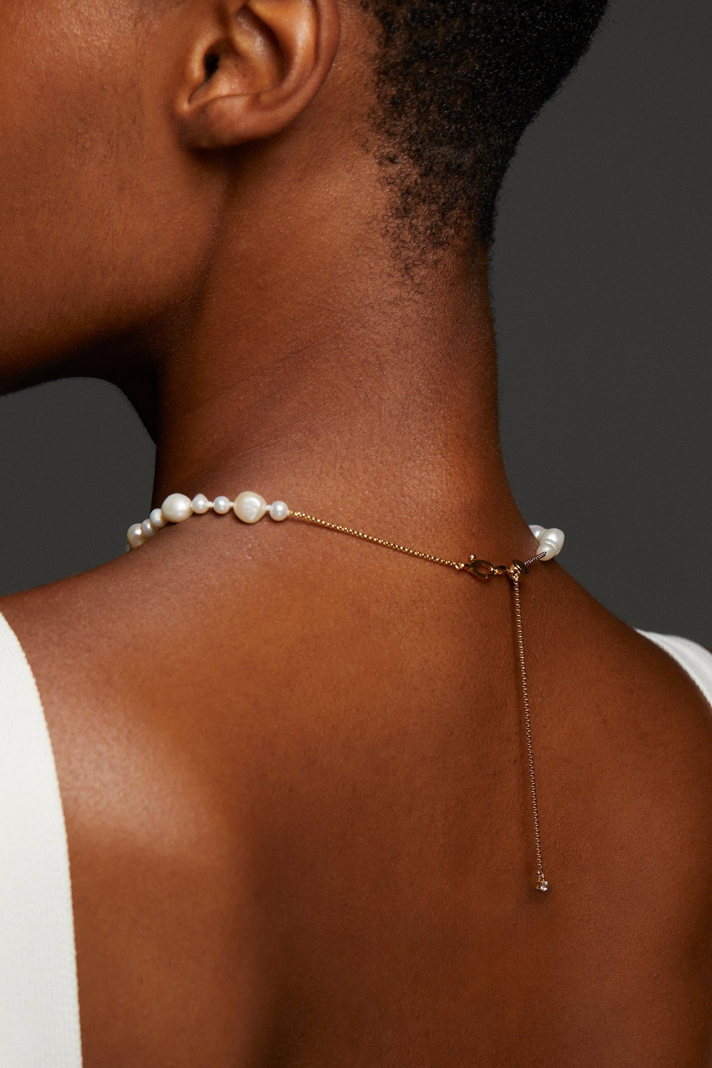 BACK VIEW OF MODEL WEARING POPPY MIXED FRESHWATER PEARL NECKLACE SHOWING A DETAIL VIEW OF THE CLASP.