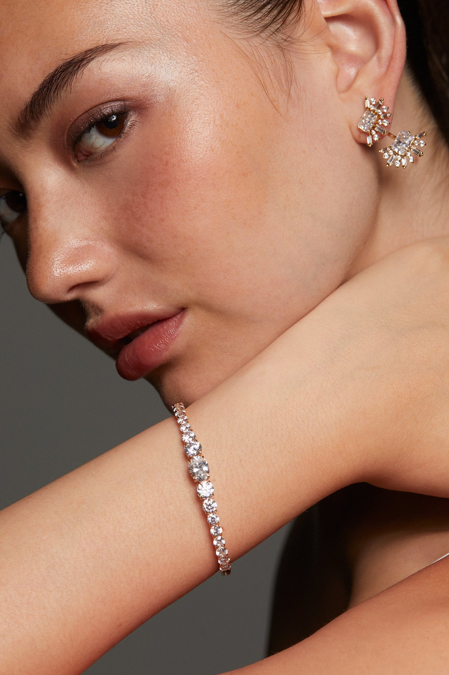 MODEL WEARING STELLAR CZ HINGE BRACELET. HER ARM IS UP TO HER CHIN AND SHE IS LOOKING DIRECTLY TOWARD THE CAMERA. 