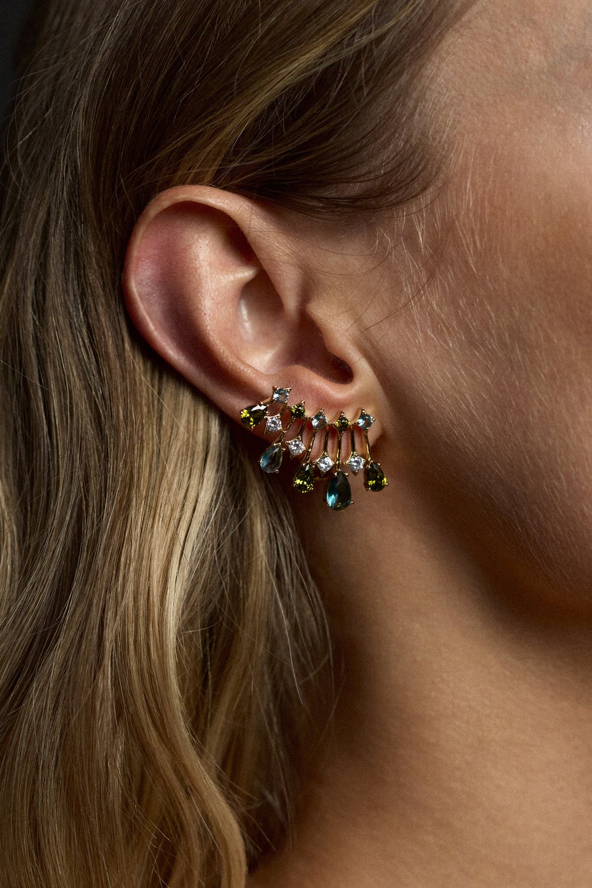 CLOSE UP OF A MODEL’S EAR WEARING THE HERA MULTI COLOR CLIMBER EARRINGS