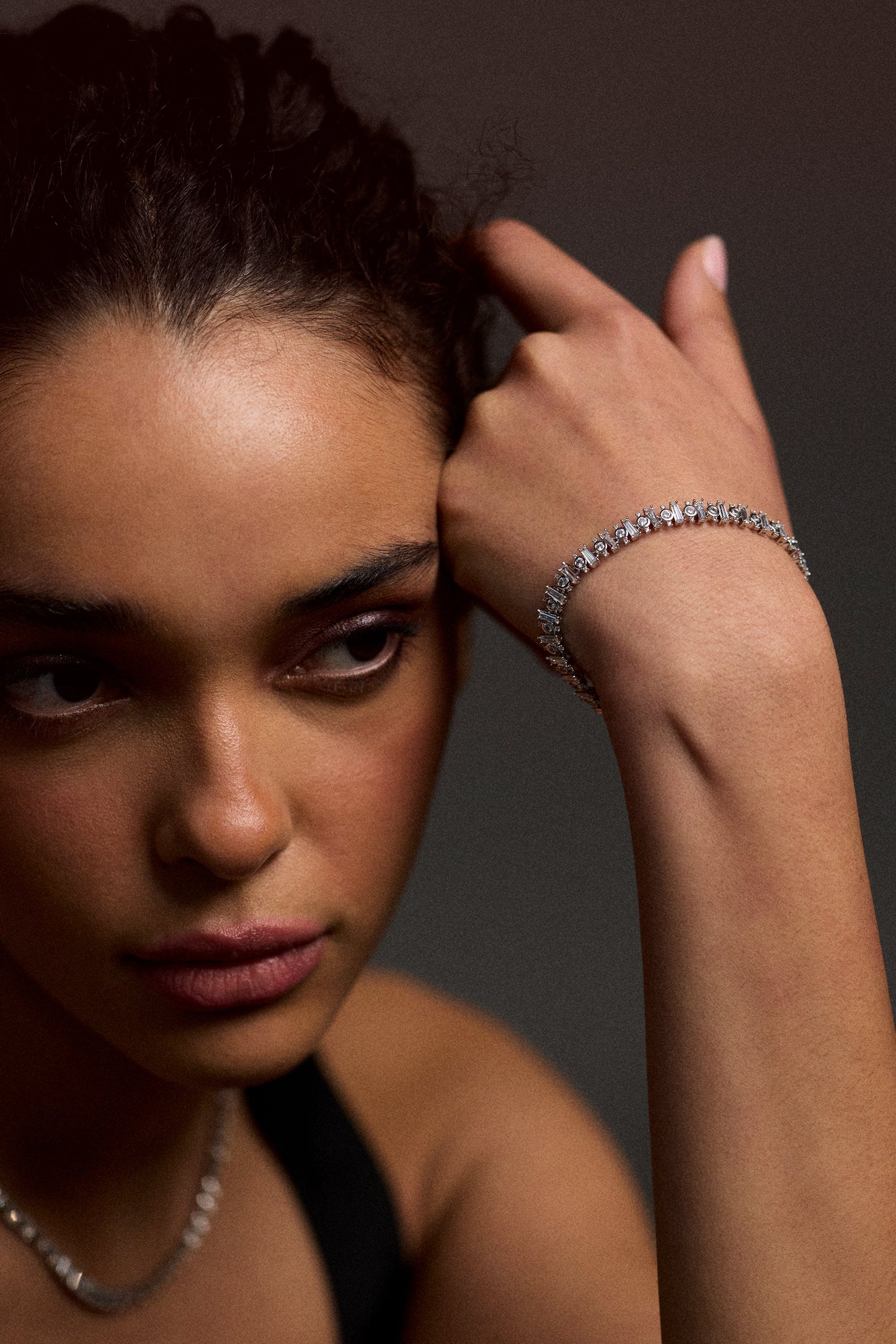 HALF OF A MODEL’S FACE LOOKING TO THE SIDE WITH HER AND LIFTED UP TO HER FOREHEAD, WEARING THE UNDER THE SEA MOSAIC LINE BRACELET