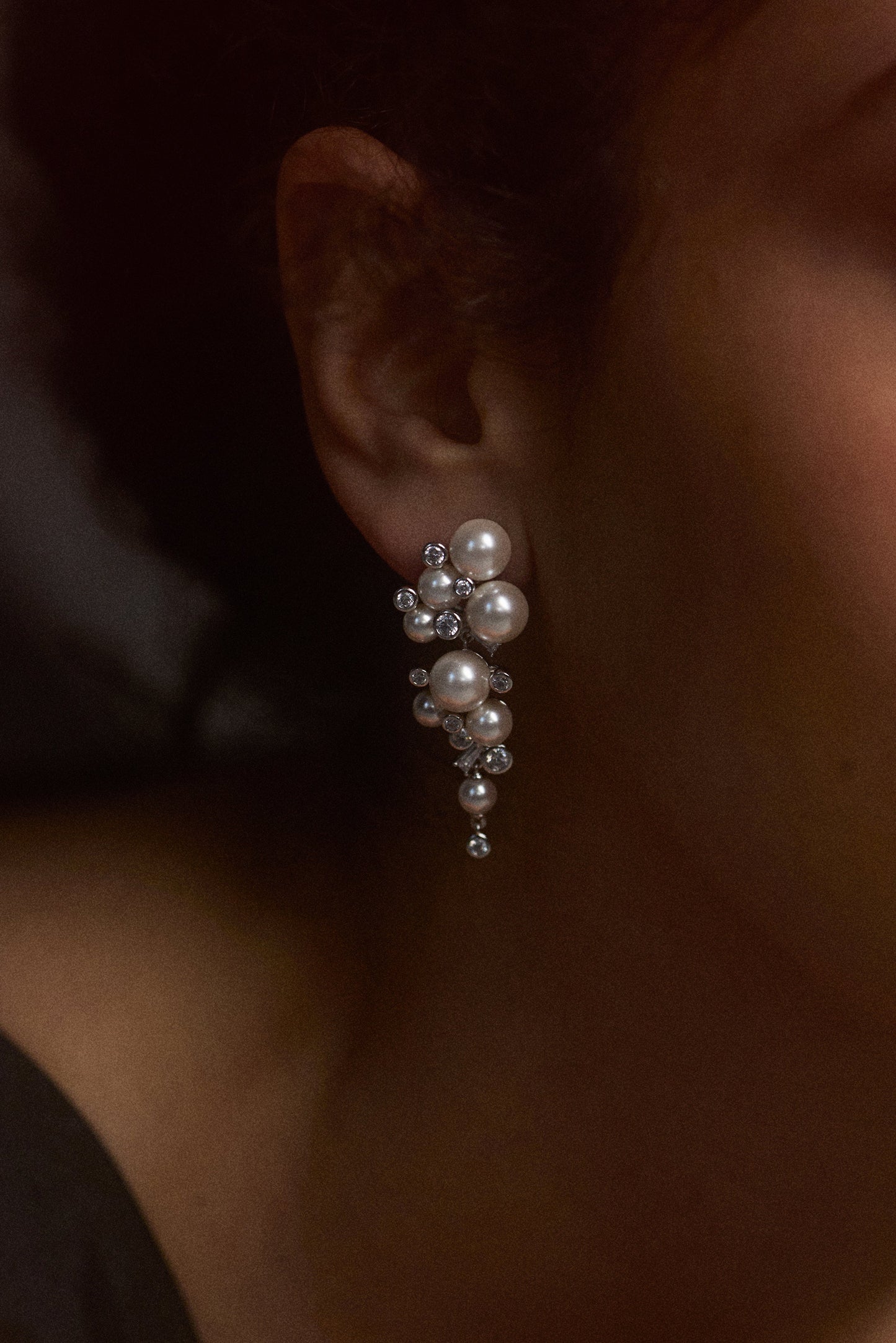CLOSE UP OF A MODEL’S EAR WEARING THE UNDER THE SEA CASCADE EARRINGS