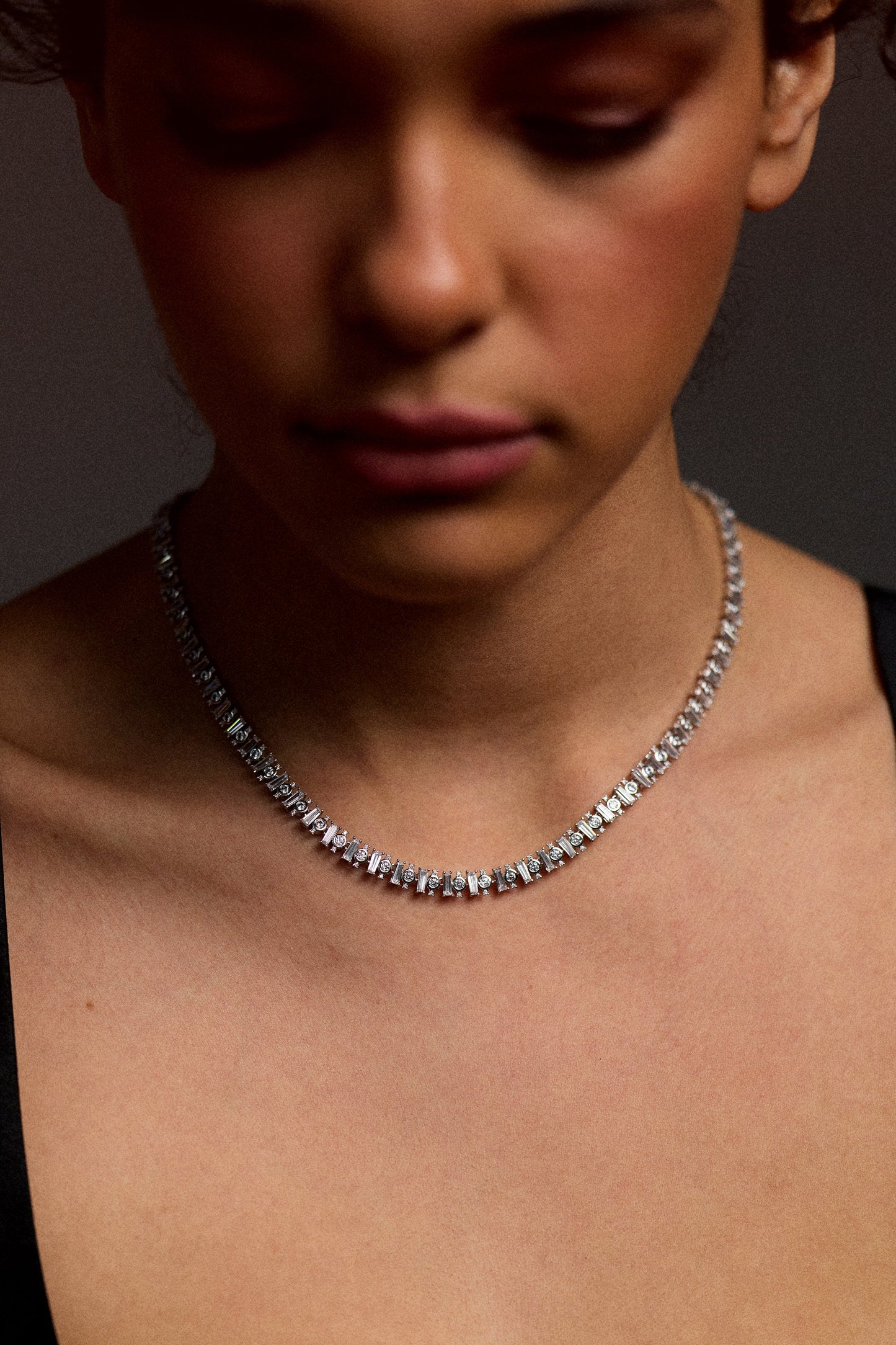 CLOSE UP OF A MODEL'S CHEST AS SHE LOOKS DOWN, WEARING A BLACK TOP AND THE UNDER THE SEA COLLAR NECKLACE.