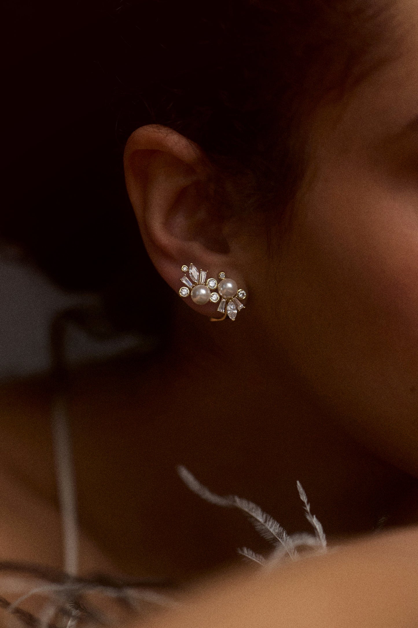 CLOSE UP OF A MODEL’S EAR WEARING THE UNDER THE SEA CLIMBER STUD EARRINGS
