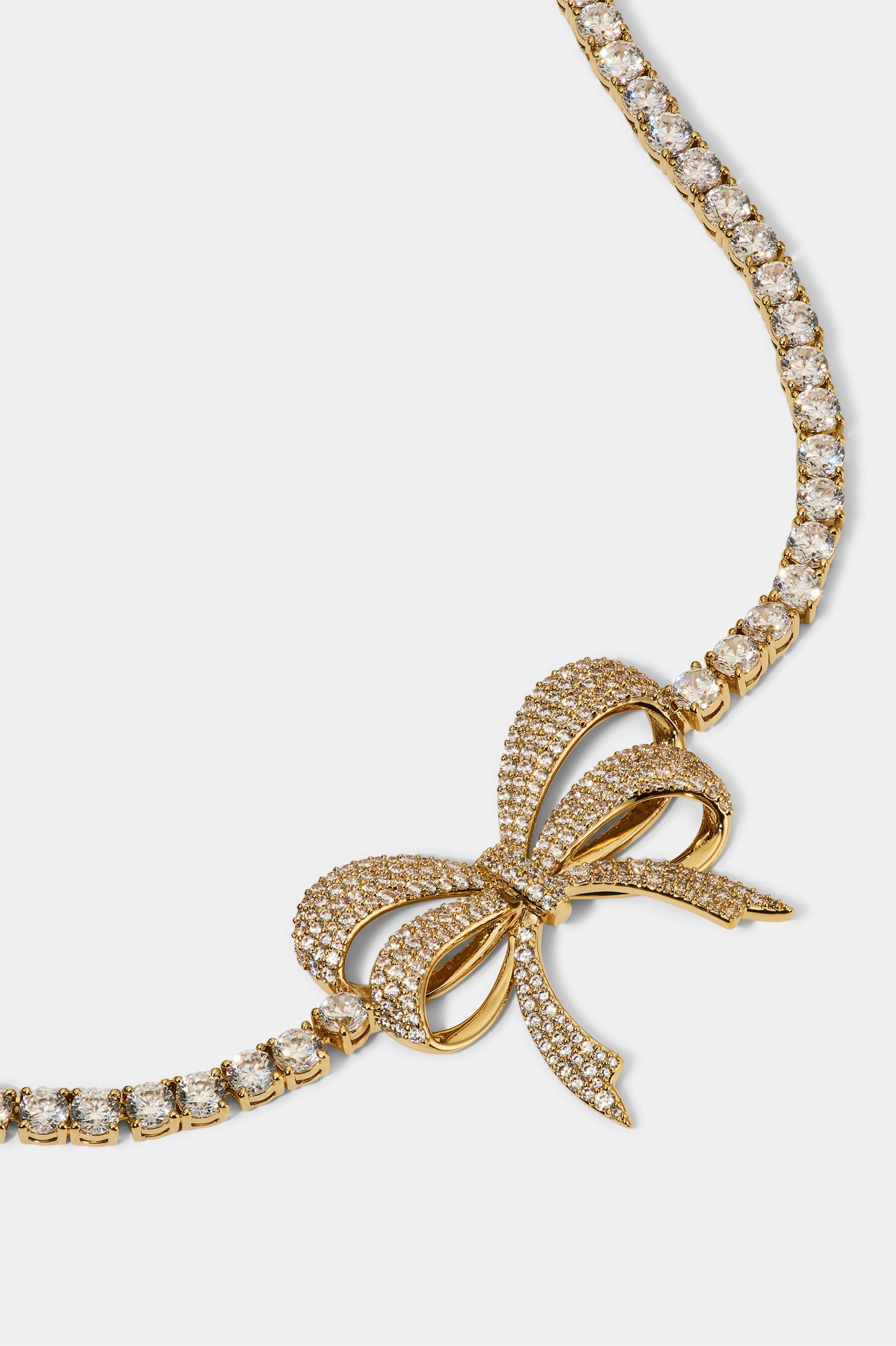 CLOSE UP OF THE BOW PENDANT OF THE EROS BOW CHOKER NECKLACE IN GOLD PLATING