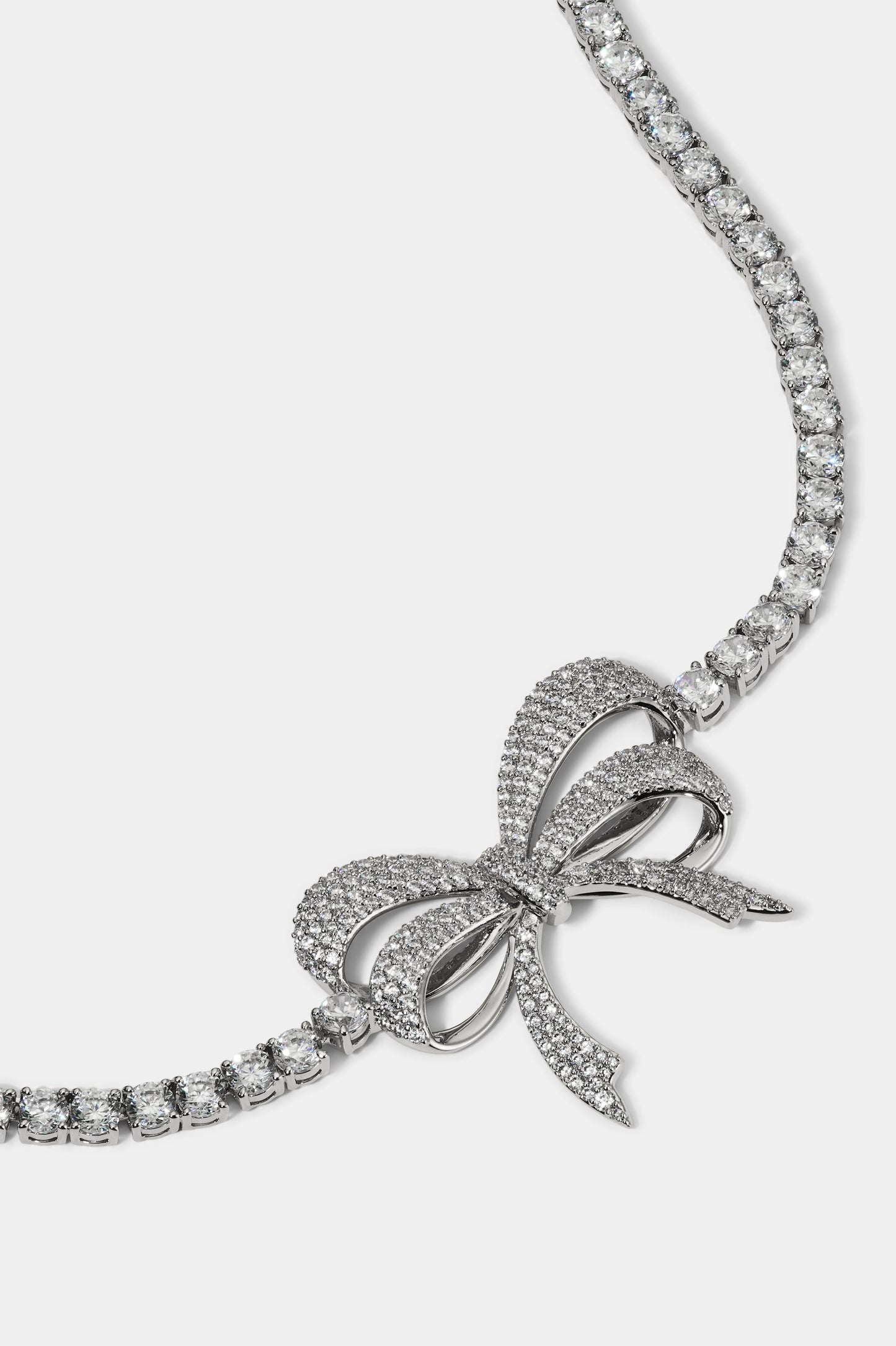 CLOSE UP OF THE BOW PENDANT OF THE EROS BOW CHOKER NECKLACE IN RHODIUM PLATING