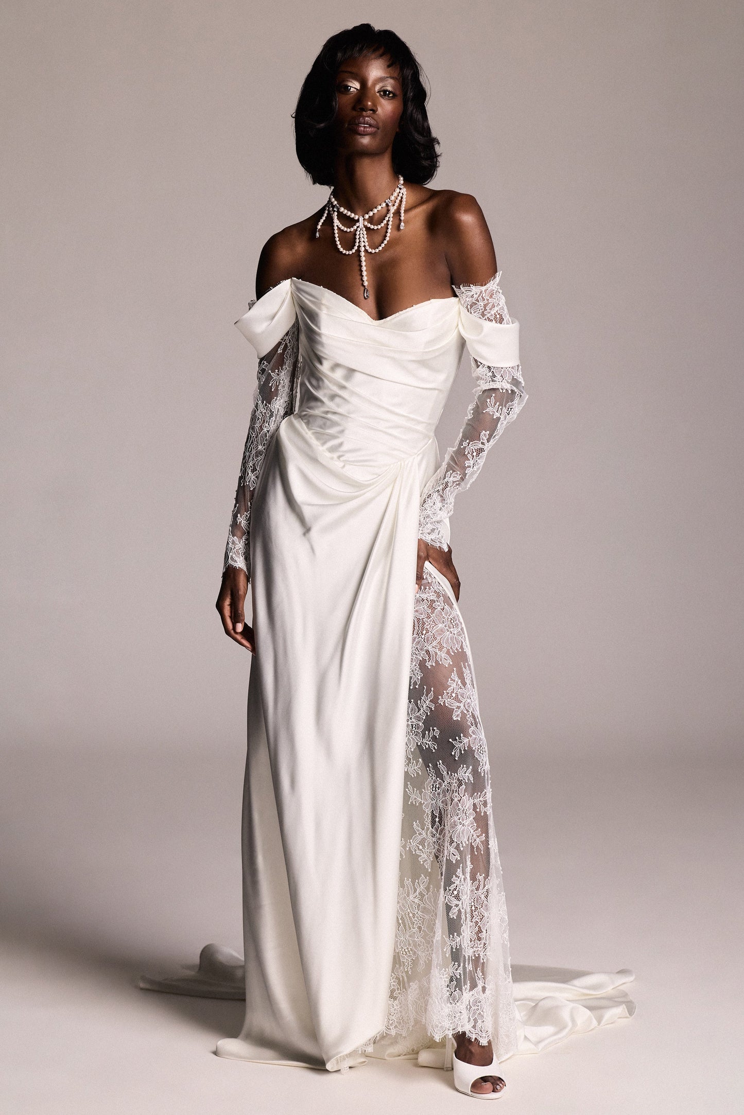 A MODEL POSING IN A WEDDING DRESS,  WEARING THE PEARL CHOKER LOW DROPS NECKLACE