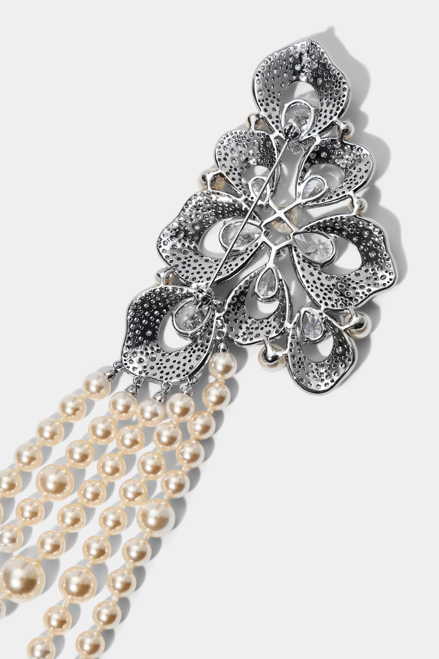 CLOSE UP OF THE FLOWER PIN ON THE PEARL SWAG BROOCH BELT, IN RHODIUM PLATING