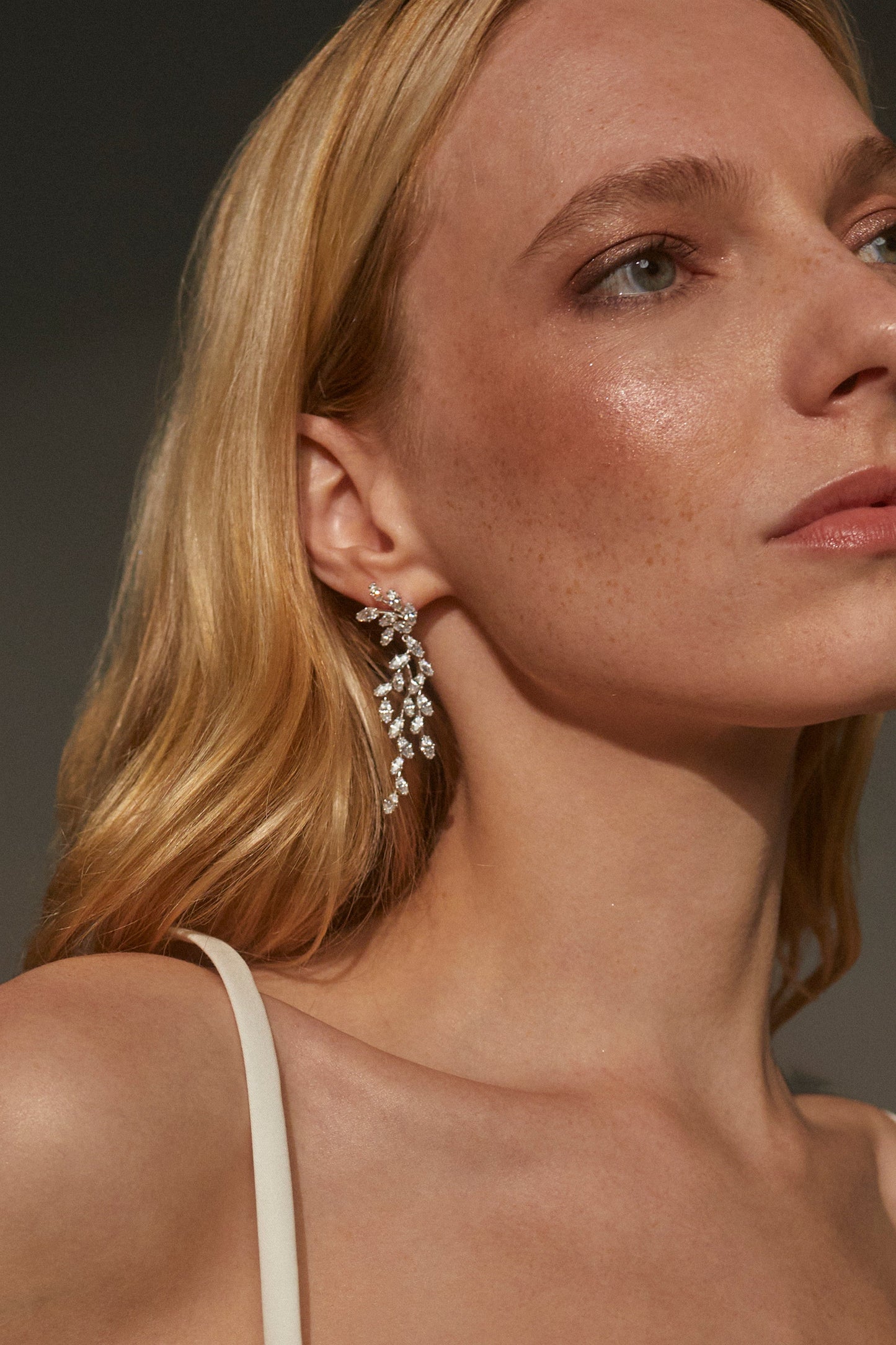 IMAGE OF A MODEL WEARING THE VOW DRAMA MARQUISE CZ EARRINGS WHILE LOOKING OFF TO THE SIDE.