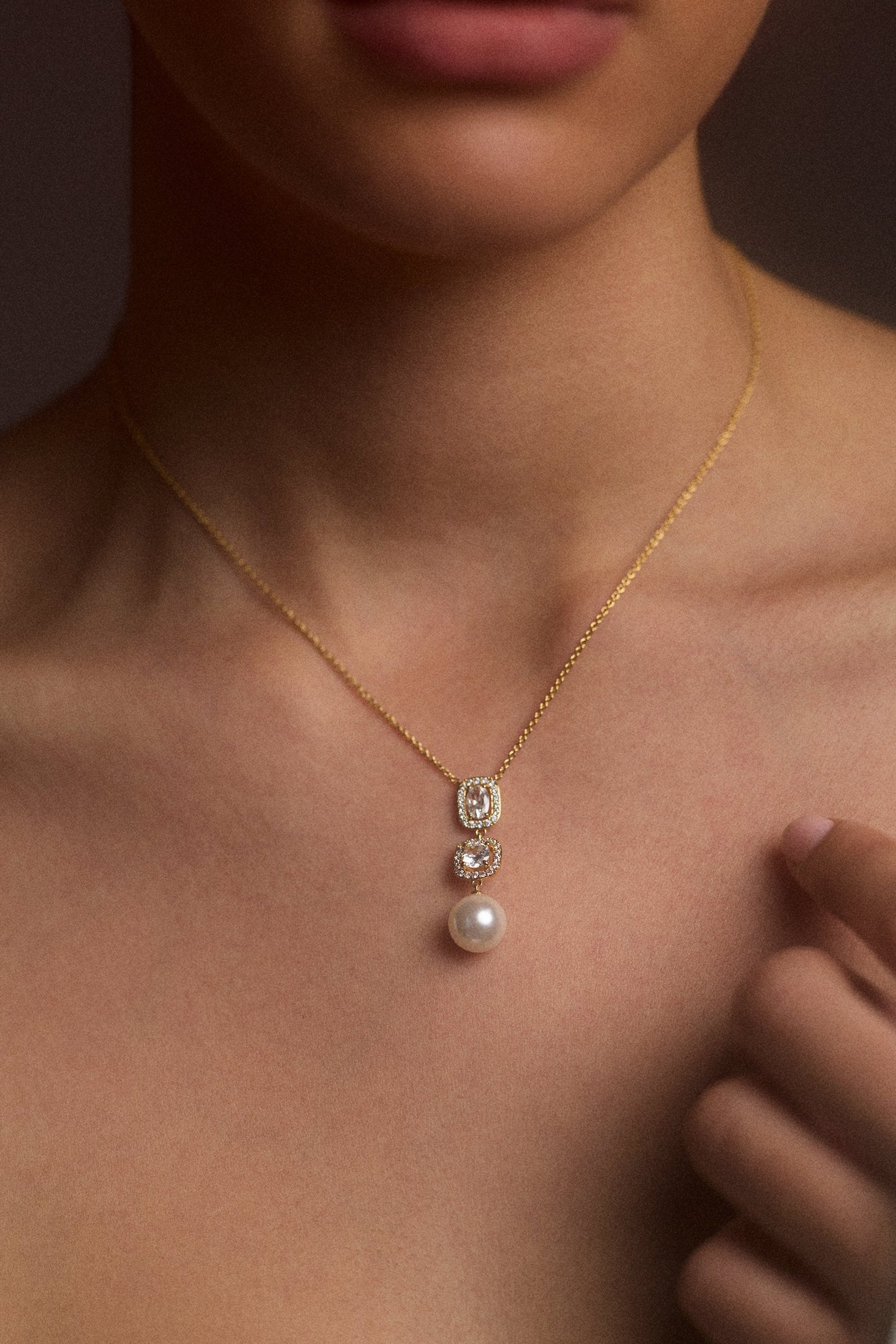 CLOSE UP OF A MODEL’S CHEST WEARING THE UNDER THE SEA CUSHION HALO PEARL Y NECKLACE