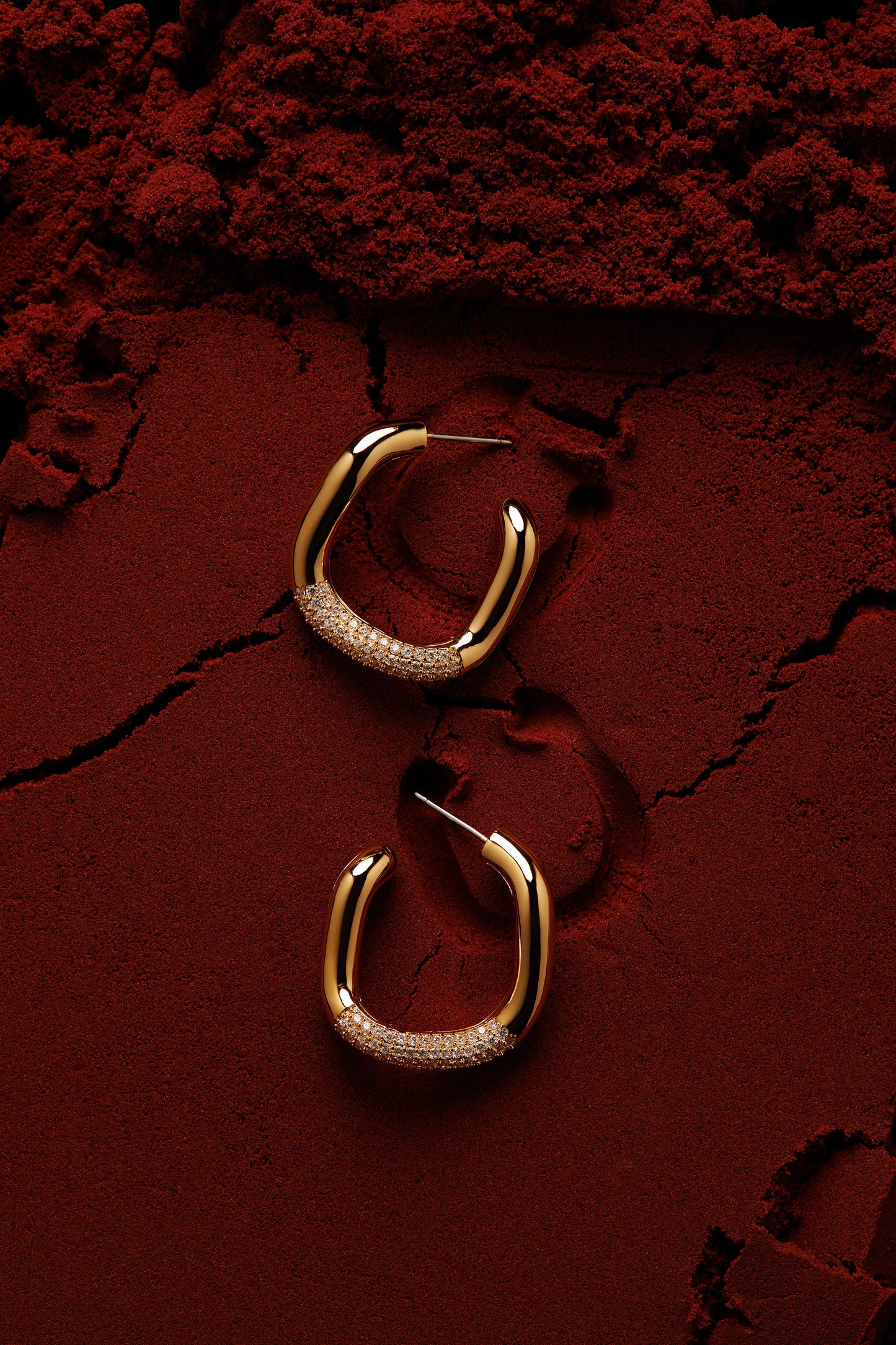 EDITORIAL STILL OF ALMA PAVE ORGANIC C HOOP EARRINGS ON RED SAND