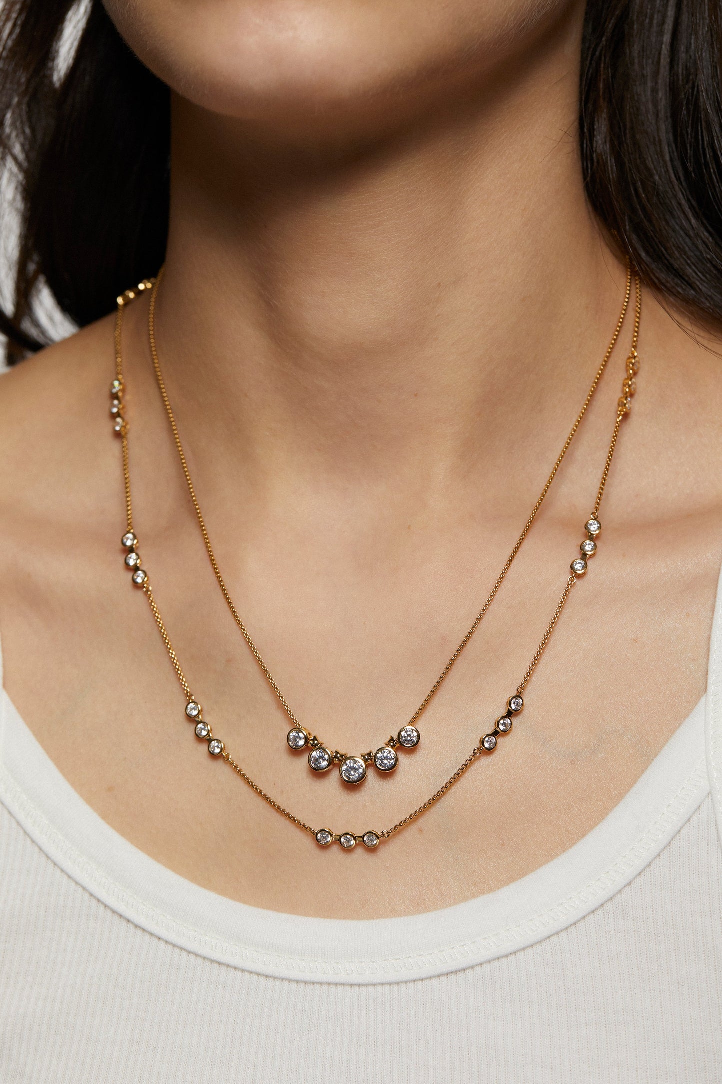 BROOKLYN DOUBLE ROW NECKLACE ON MODEL. IT IS A CLOSE UP IMAGE OF HER NECKLINE. SHE IS WEARING A WHITE TANK TOP.
