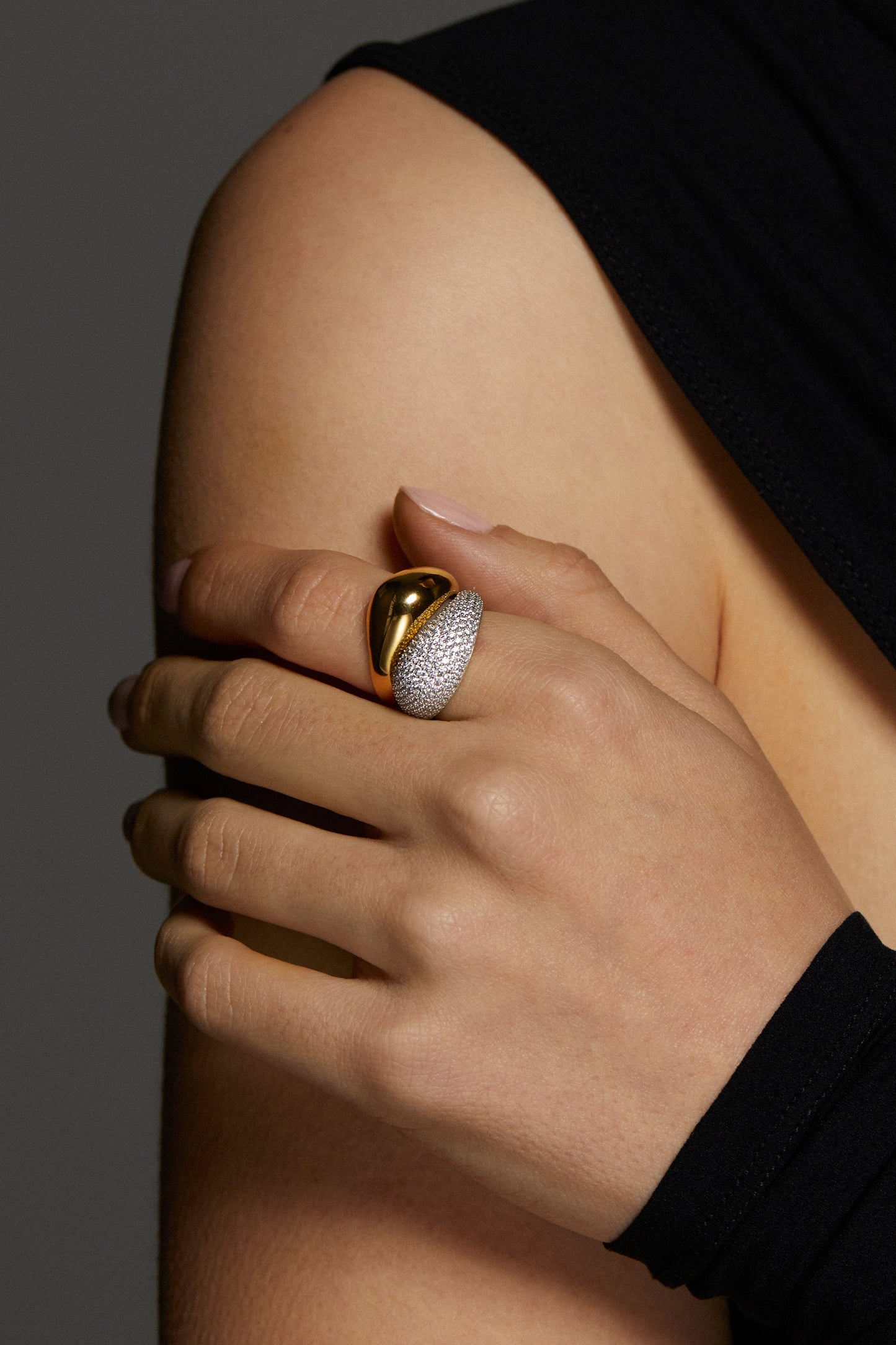 MODEL WEARING DRIP DUO RING SET. IT IS A CLOSE UP IMAGE OF HER HAND ON HER SHOULDER. SHE IS WEARING A BLACK ONE SHOULDER TOP. 