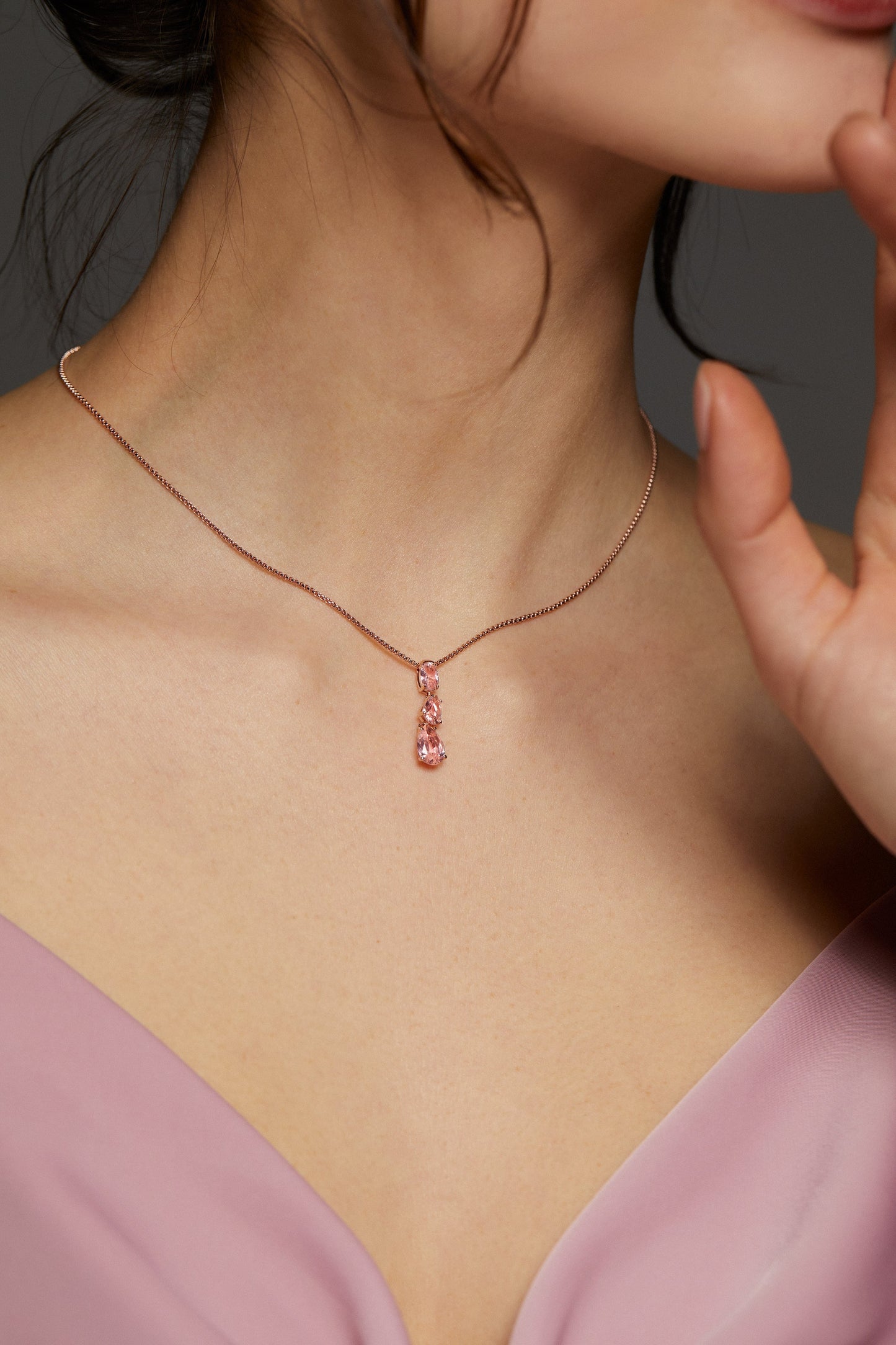 MODEL WEARING NATURAL BEAUTY PINK SHORT Y NECKLACE. IT IS A CLOSE UP IMAGE OF HER NECKLINE. SHE HAS ON A LIGHT PINK DRESS.
