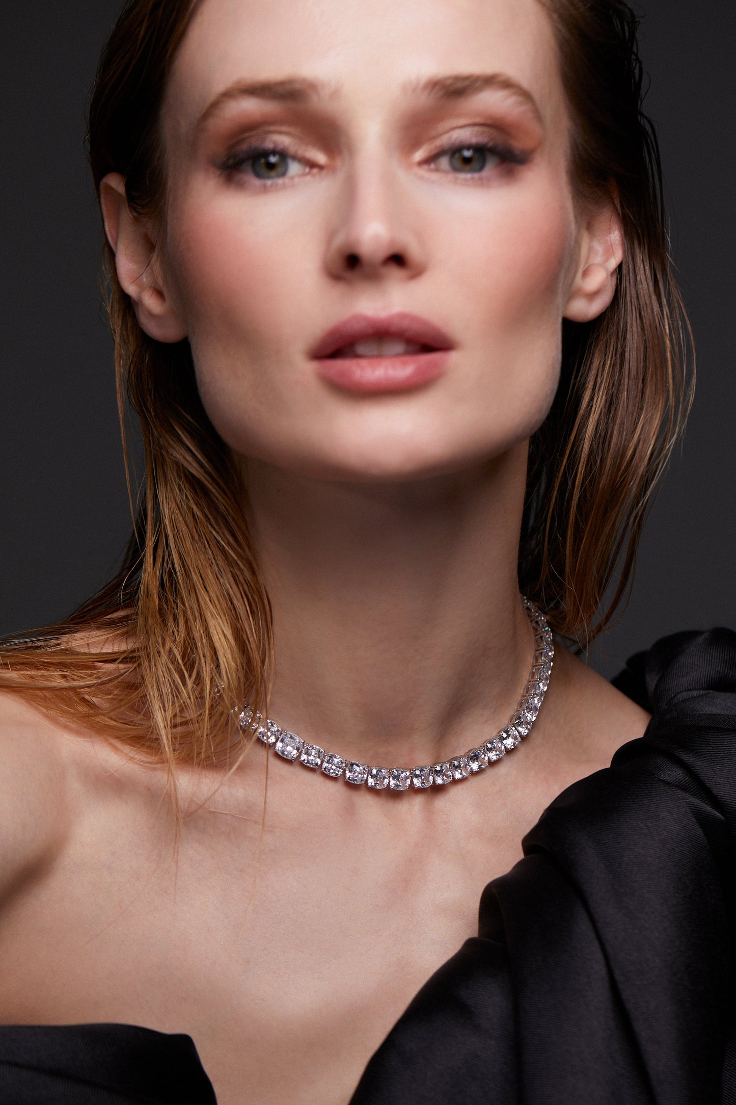 MODEL WEARING STARLET CUSHION COLLAR NECKLACE. SHE IS LOOKING DIRECTLY TO THE CAMERA. SHE IS WEARING A BLACK DRESS WITH HER HAIR SLICKED BACK AND TUCKED BEHIND HER EARS. 
