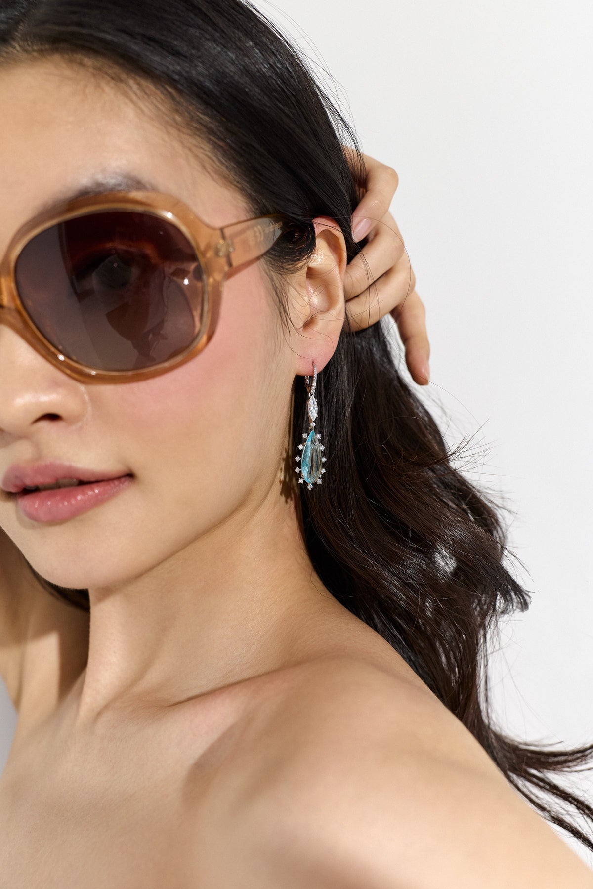 IMAGE OF MODEL IN SUNGLASSES WEARING NADRI'S MOJITO TEAL PEAR DROP EARRINGS