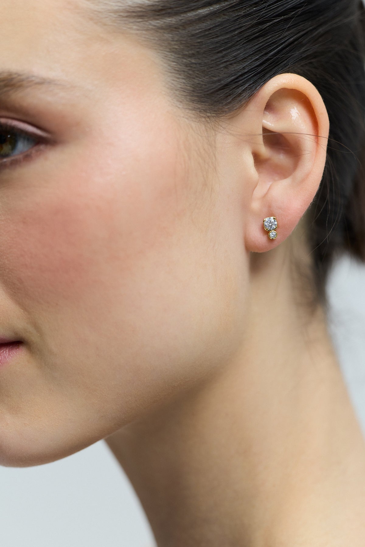 CLOSE UP OF THE SIDE PROFILE OF A MODEL, AS SHE WEARS THE DOUBLE STONE STUD FROM THE DELANCEY STUD SET OF EARRINGS
