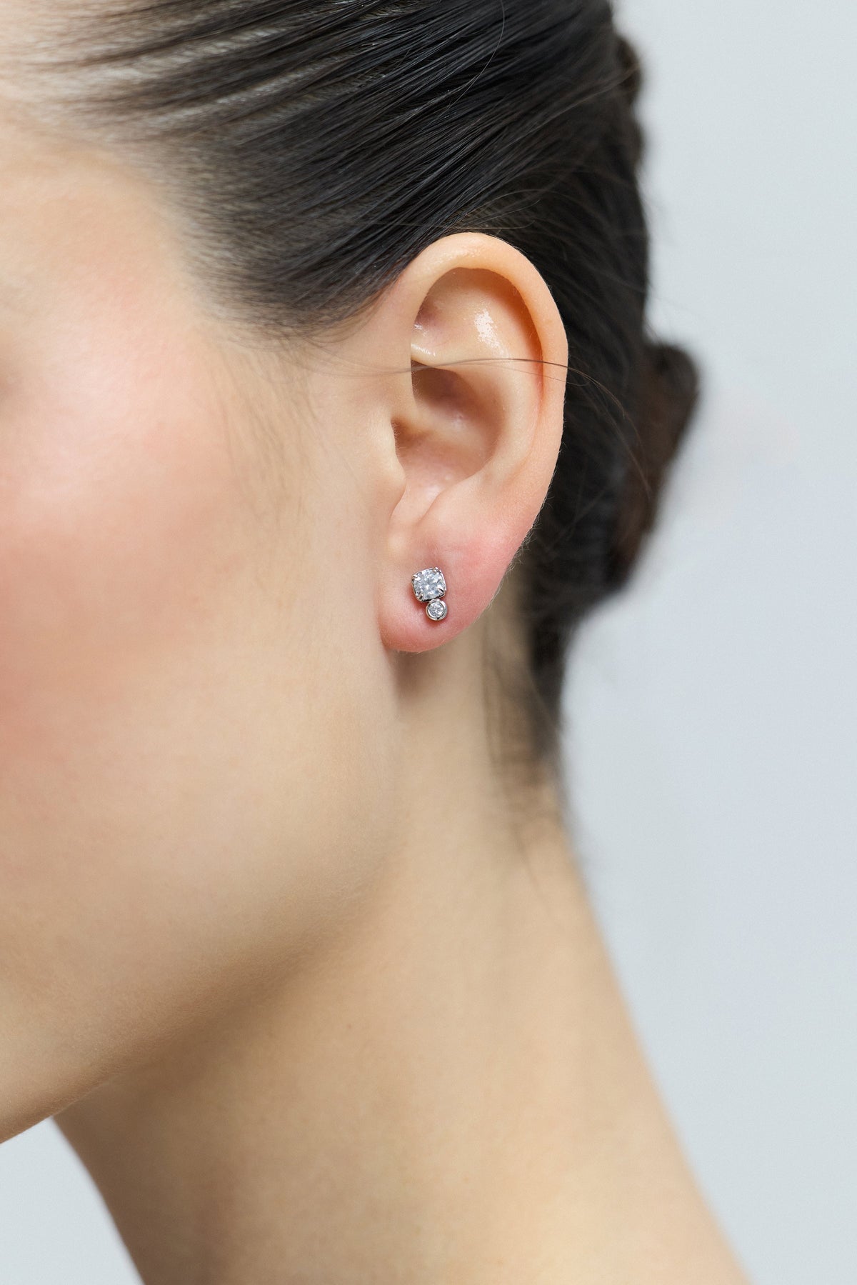 CLOSE UP OF A MODEL’S EAR, WEARING THE DOUBLE STONE STUD FROM THE DELANCEY STUD SET OF EARRINGS