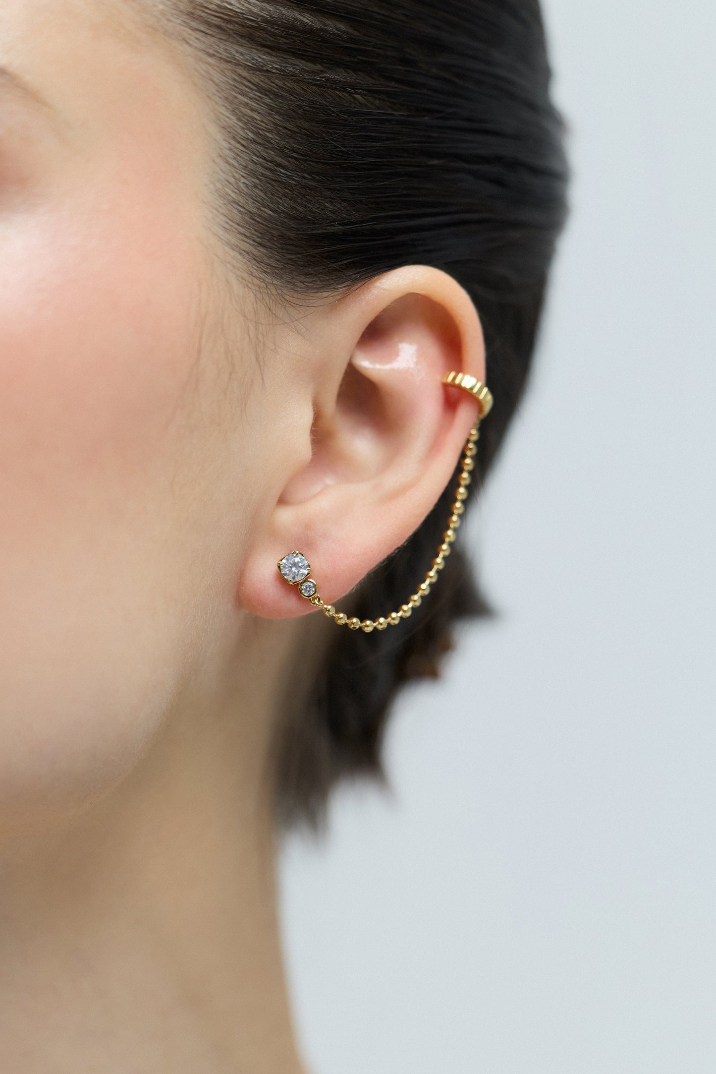 CLOSE UP OF A MODE’S EAR WEARING THE DELANCEY SINGLE SWAG CUFF EARRINGS