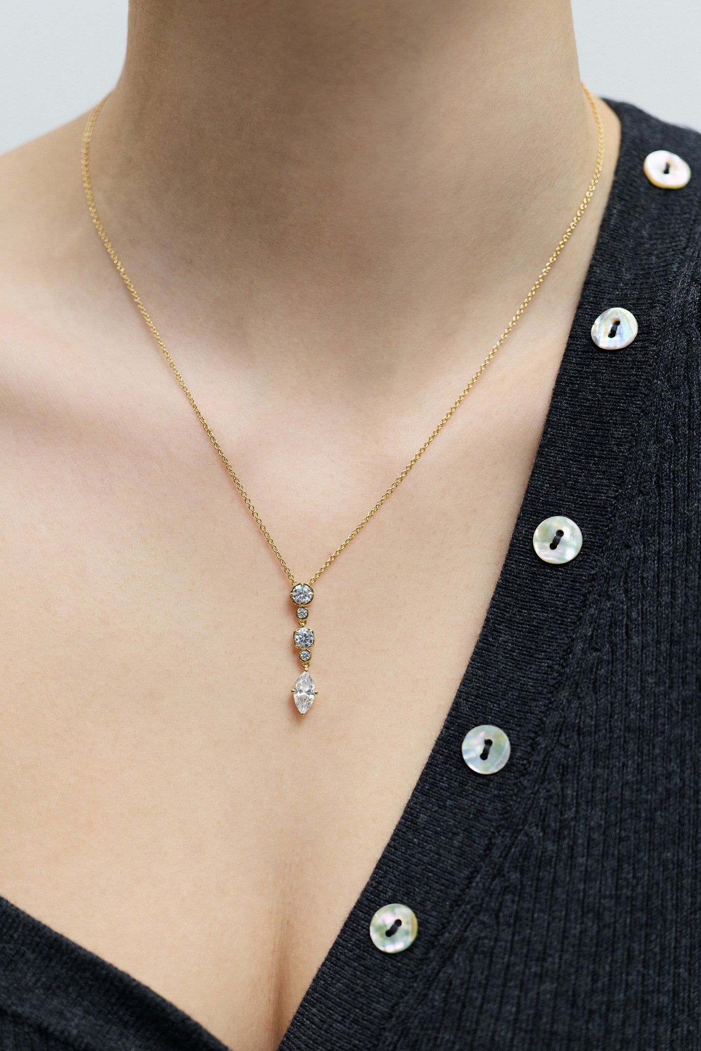 CLOSE UP OF A MODEL’S CHEST WEARING A GRAY SWEATER AND THE DELANCEY SHORT Y NECKLACE