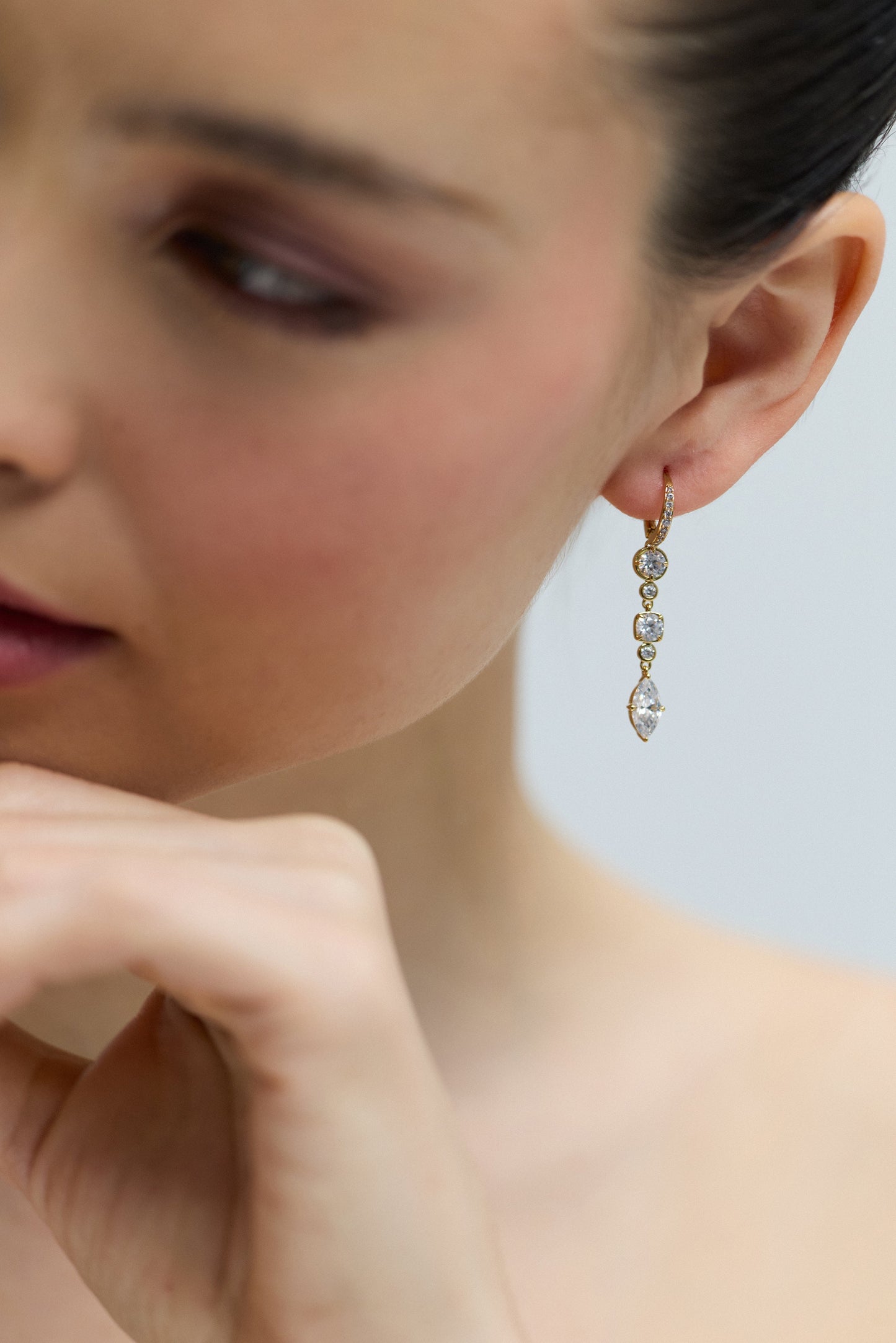CLOSE UP OF A MODEL’S HEAD TURNED SLIGHTLY TO THE SIDE WITH HER EAR IN FOCUS, AS SHE WEARS THE DELANCEY LINEAR LEVERBACK EARRINGS