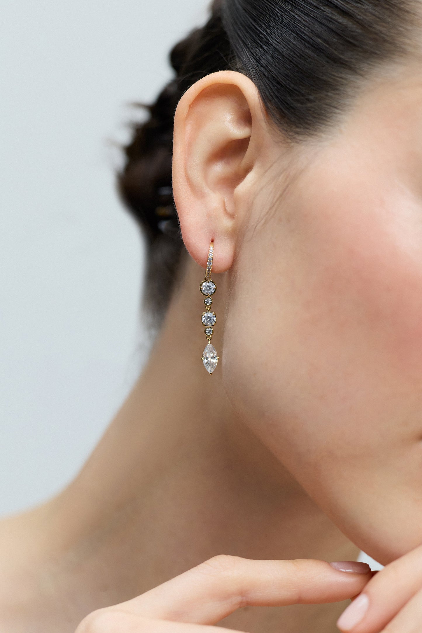 CLOSE UP OF A MODEL’S EAR WITH HER HEAD TURNED TO THE SIDE, AS SHE WEARS THE DELANCEY LINEAR LEVERBACK EARRINGS