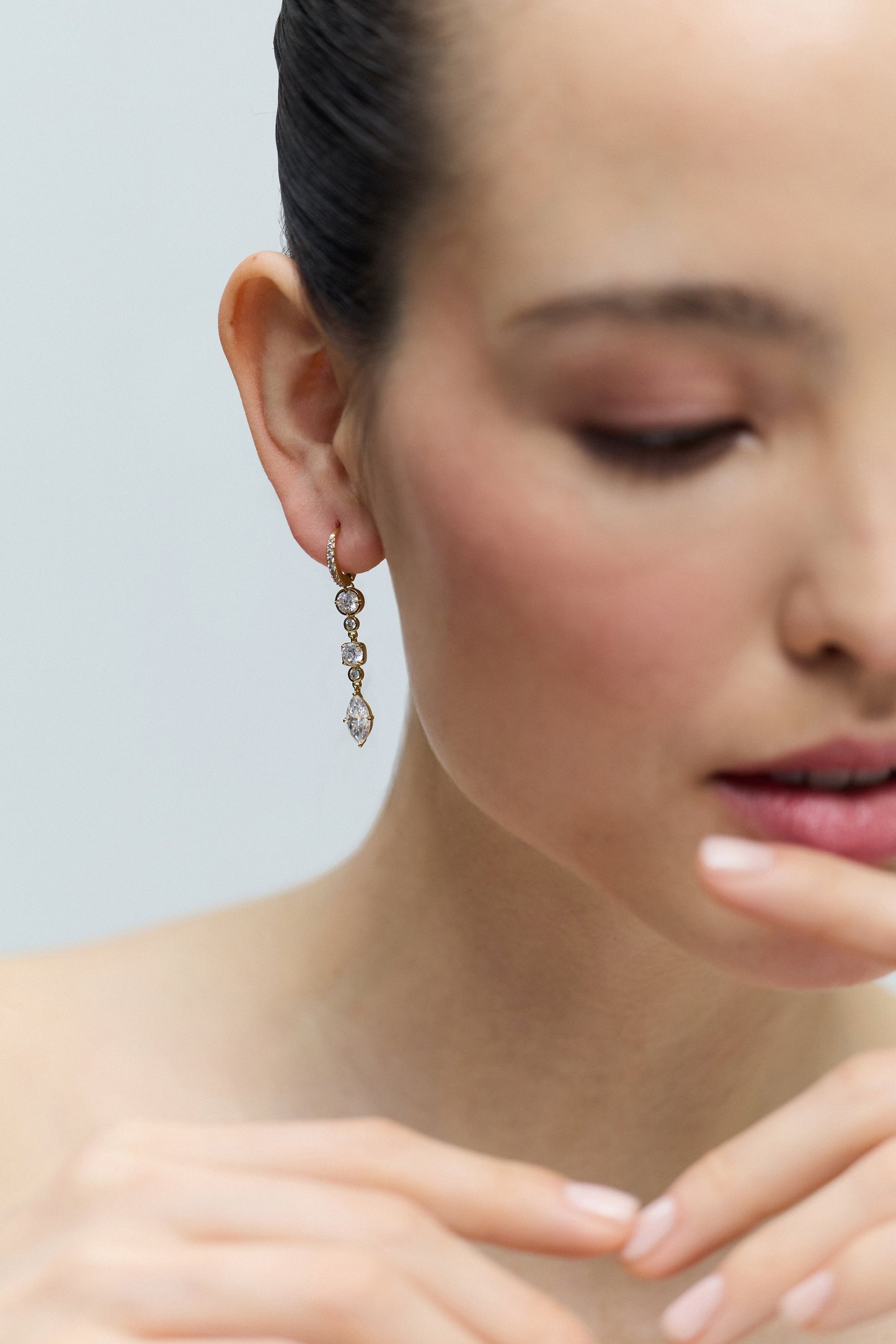 CLOSE UP OF HALF OF A MODEL’S FACE WITH JUST HER EAR IN FOCUS, WEARING THE DELANCEY LINEAR LEVERBACK EARRINGS