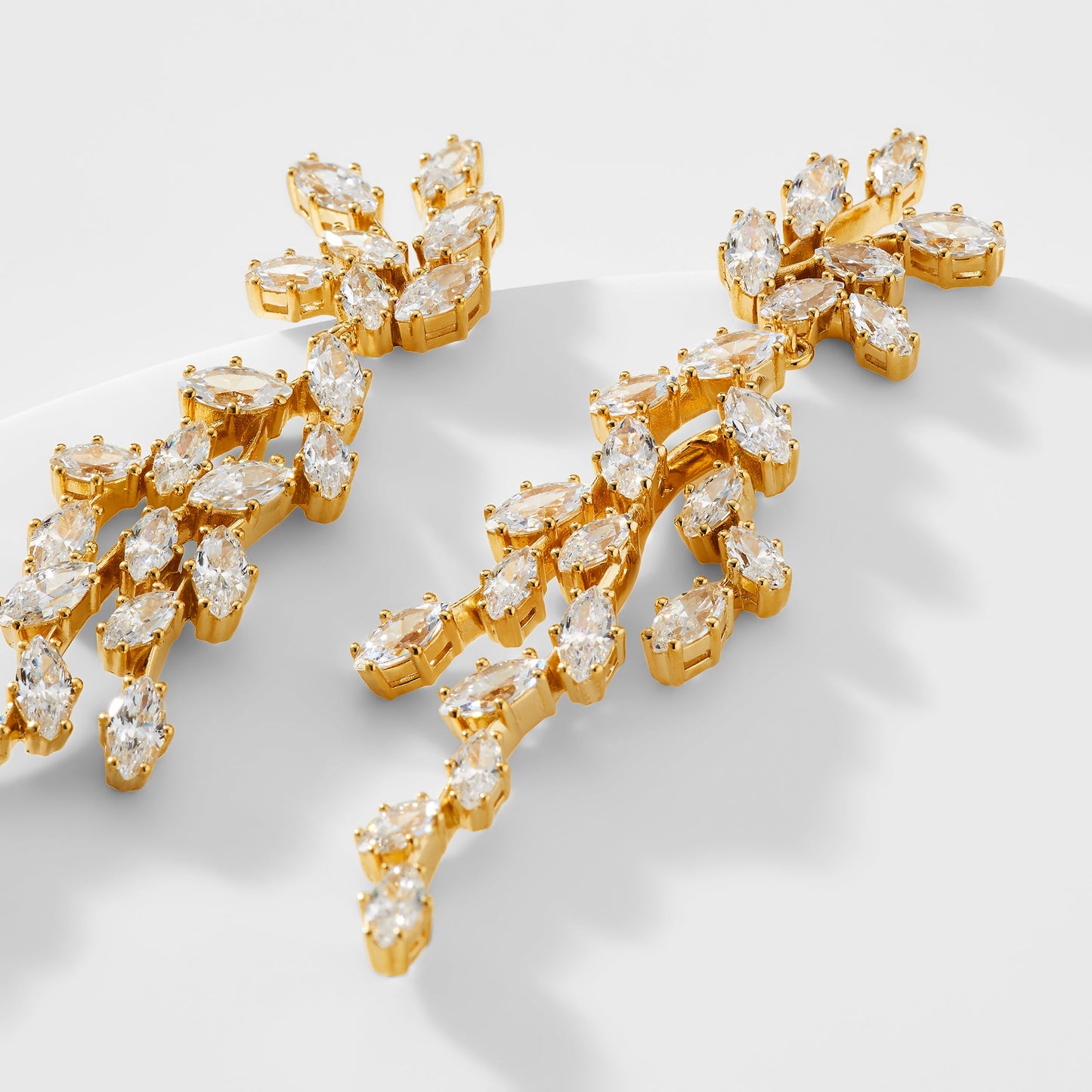 CLOSE UP DETAILED IMAGE OF THE VOW DRAMA MARQUISE CZ EARRINGS IN GOLD PLATING.