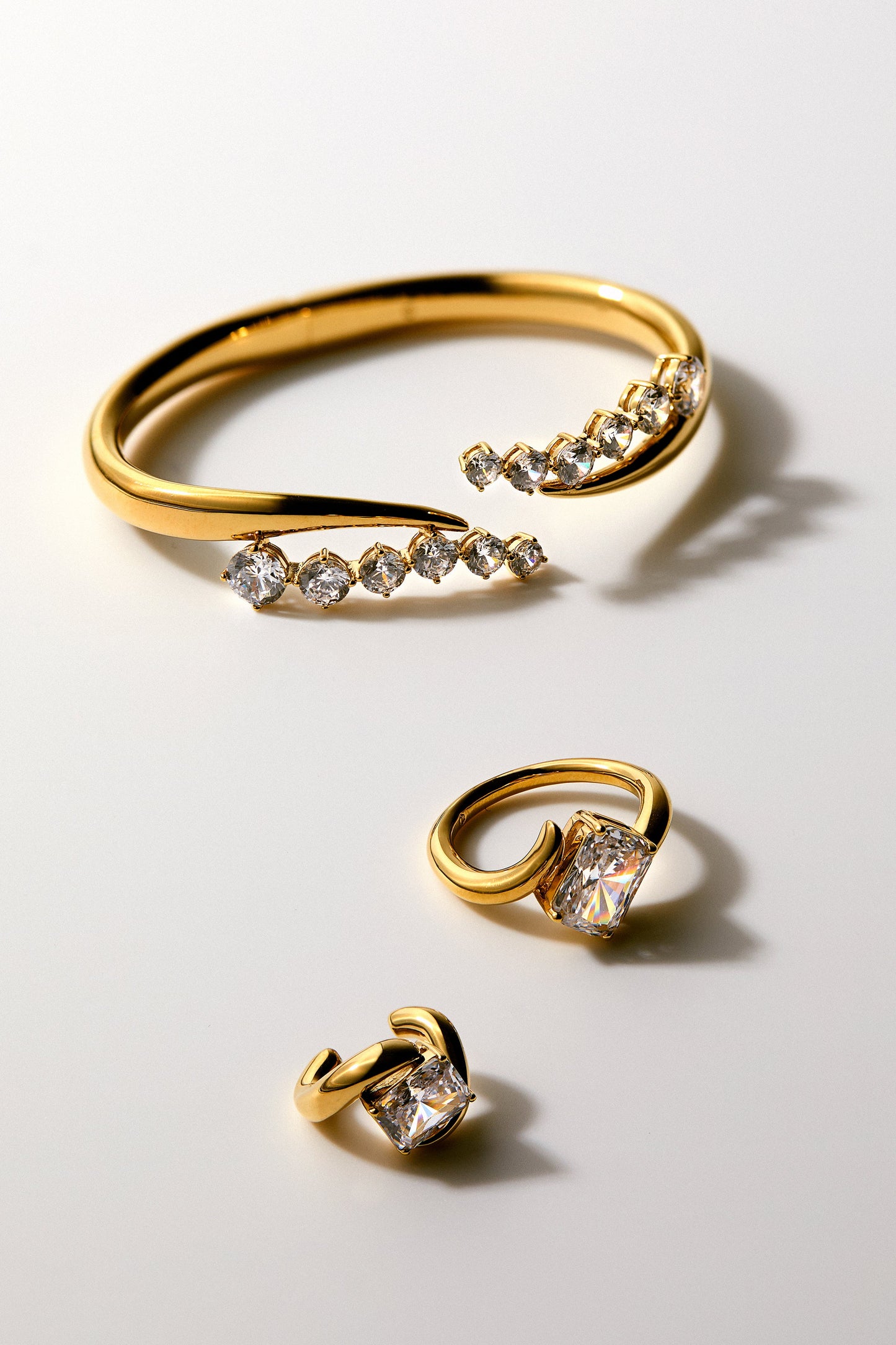 PHENOM CUFF BRACELET, RING, AND CUFF EARRING AGAINST A NEUTRAL BACKGROUND.