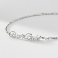 A silver chain bracelet that says "Boss Babe" with a cubic zirconia stone