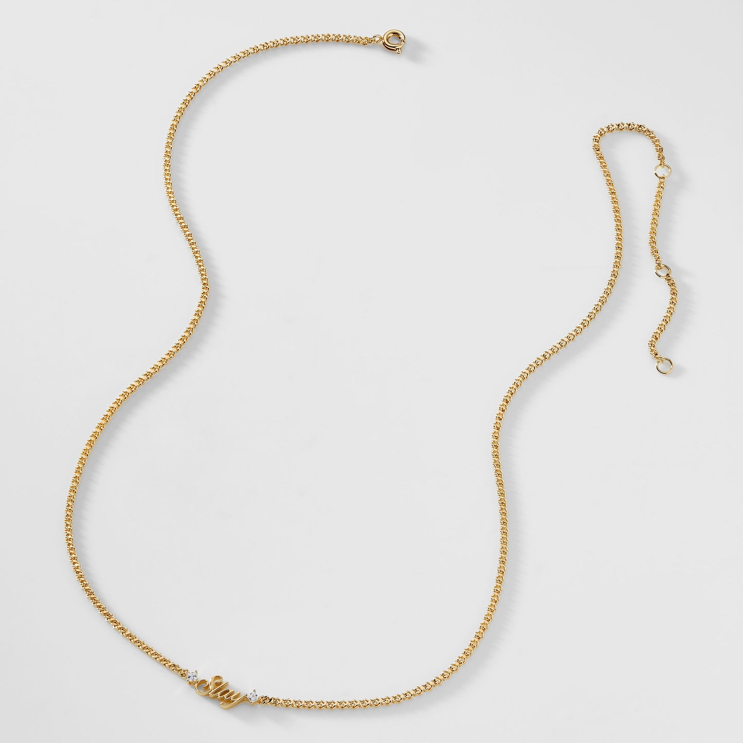 A gold chain necklace that says "Slay" with two cubic zirconia stones